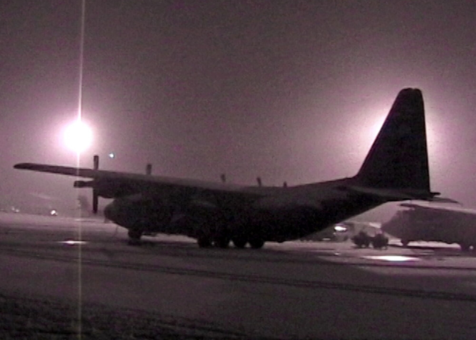 A snow-covered C-130 sits on the ramp at Bagram Air Base, Afghanistan, as deployed 711th Special Operations Squadron members of 'Daddy 05' return from a medical evacuation in 2009.  Due to heavy snowstorms and poor visibility, the Duke Field  reservist aircrew had to receive a waiver just to land.  The medical evacuation mission was a success in that all the critically wounded passengers survived after suffering injuries from a suicide bomber.  (Photo still from video source)
