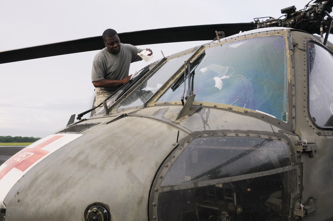 MANAGUA, Nicaragua --  Cleaning the pilots' windows, Sgt. First Class Gregory Givings, of the 1-228th Aviation Regiment, prepares a UH-60 Black Hawk helicopter for departure Sept. 20 here. The Black Hawk was one of four helicopters going to the USS Iwo Jima in support of Operation Continuing Promise 2010. (U.S. Air Force photo/Tech. Sgt. Benjamin Rojek)