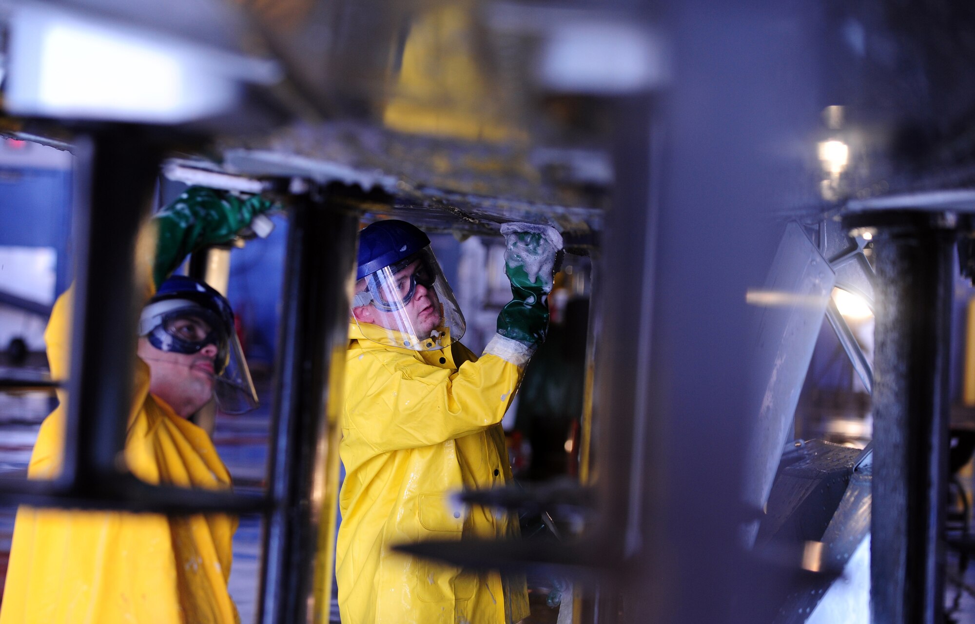 OFFUTT AIR FORCE BASE, Neb. - Senior Airmen Anthony Buum (left) and Timothy Odell (right), both from the 55th Aircraft Maintenance Squadron, do a detailed cleaning in-between the lower antennas of an RC-135V Rivet Joint aircraft, inside hangar five of the Bennie Davis Maintenance Facility, Sept. 28.  Roughly ten crew chiefs assigned to the 55th AMXS perform routine cleanings of the airframes, which often take up to eight hours to accomplish. The cleanings are part of a minor corrosion and control inspection which is followed by a full lubrication of the entire aircraft once cleaned. U.S. Air Force photo by Josh Plueger

