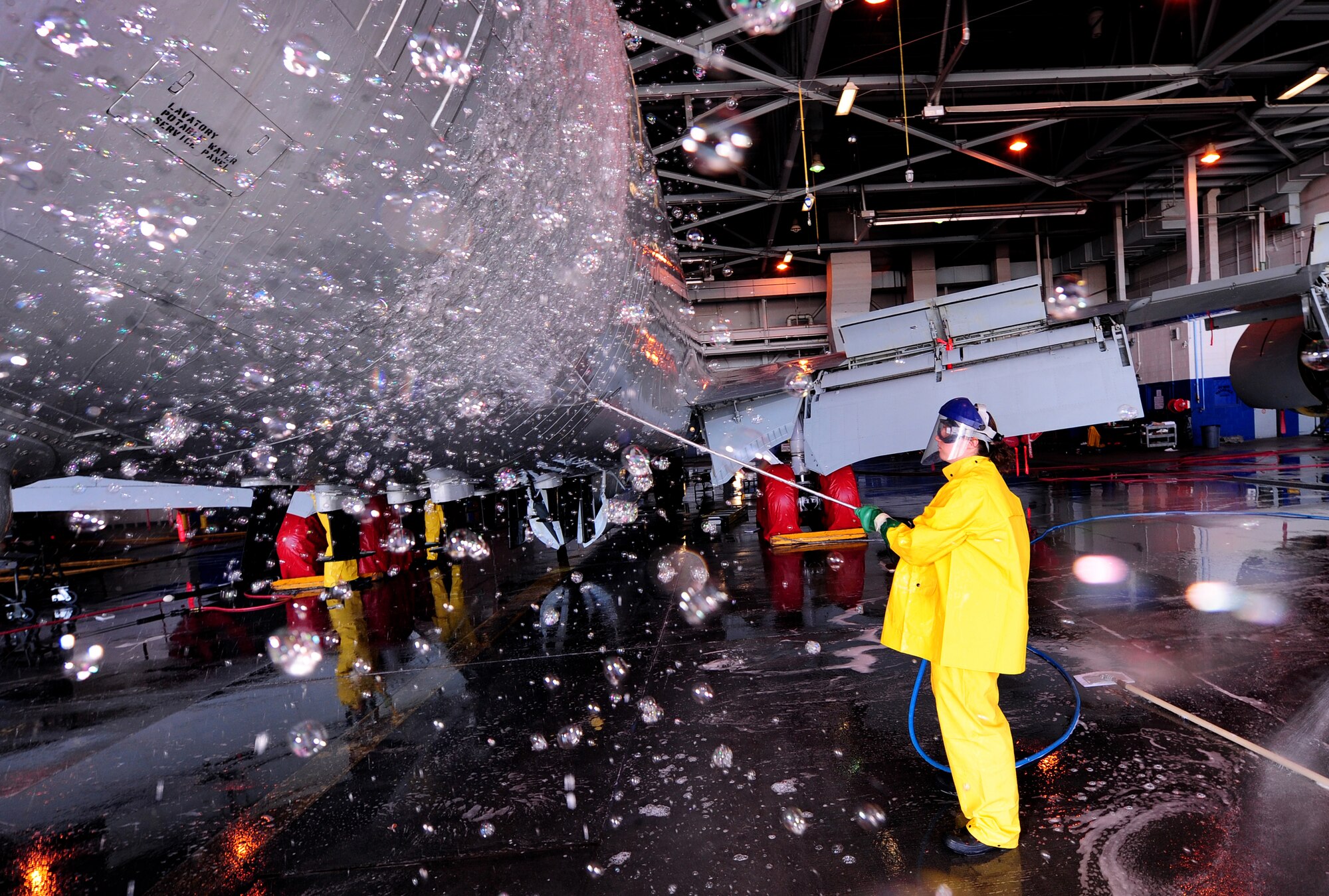 OFFUTT AIR FORCE BASE, Neb. - Airman 1st Class Tia Phakos, of the 55th Aircraft Maintenance Squadron, shoots soap suds onto the tail end of an RC-135V Rivet Joint aircraft, inside hangar five of the Bennie Davis Maintenance Facility, Sept. 28.  Roughly ten crew chiefs assigned to the 55th AMXS perform routine cleanings of the airframes which often take up to eight hours to accomplish. The cleanings are part of a minor corrosion and control inspection which is followed by a full lubrication of the entire aircraft once cleaned. U.S. Air Force photo by Josh Plueger