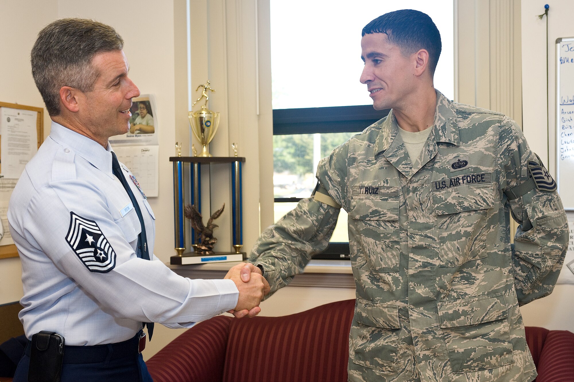 Chief Master Sgt. David E. Spector, Command Chief Master Sergeant for Air Mobility Command, congratulates Tech. Sgt. Alex Ruiz on Sept. 20, 2010, at Dover Air Force Base, Del., after Sergeant Ruiz was promoted to technical sergeant through the Stripes for Exceptional Performers program by Col. Manson Morris, 436th Airlift Wing commander. (U.S. Air Force Photo/Mr. Roland Balik)