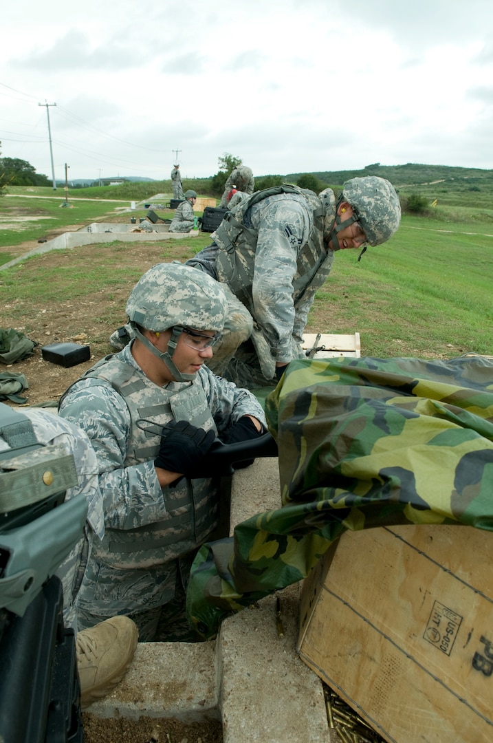 Gunner SrA Salvador Gutierrez and assistant gunner A1C Matthew Allen prepare M-249 for another round of firing at Camp Bullis, TX.  (U.S. Air Force photo/Steve White)