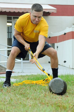 Master-at-Arms 1st Class Jake Moore, the command fitness leader for Naval Support Activity, demonstrates his physical proficiency as part of an obstacle course held during morning physical training at Sam's Gym on Joint Base Charleston - Weapons Station. Master-at-Arms Moore is attached to the Security Department, NSA CHS. (U.S. Navy photo/Mass Communications Specialist 1st Class Jennifer Hudson)