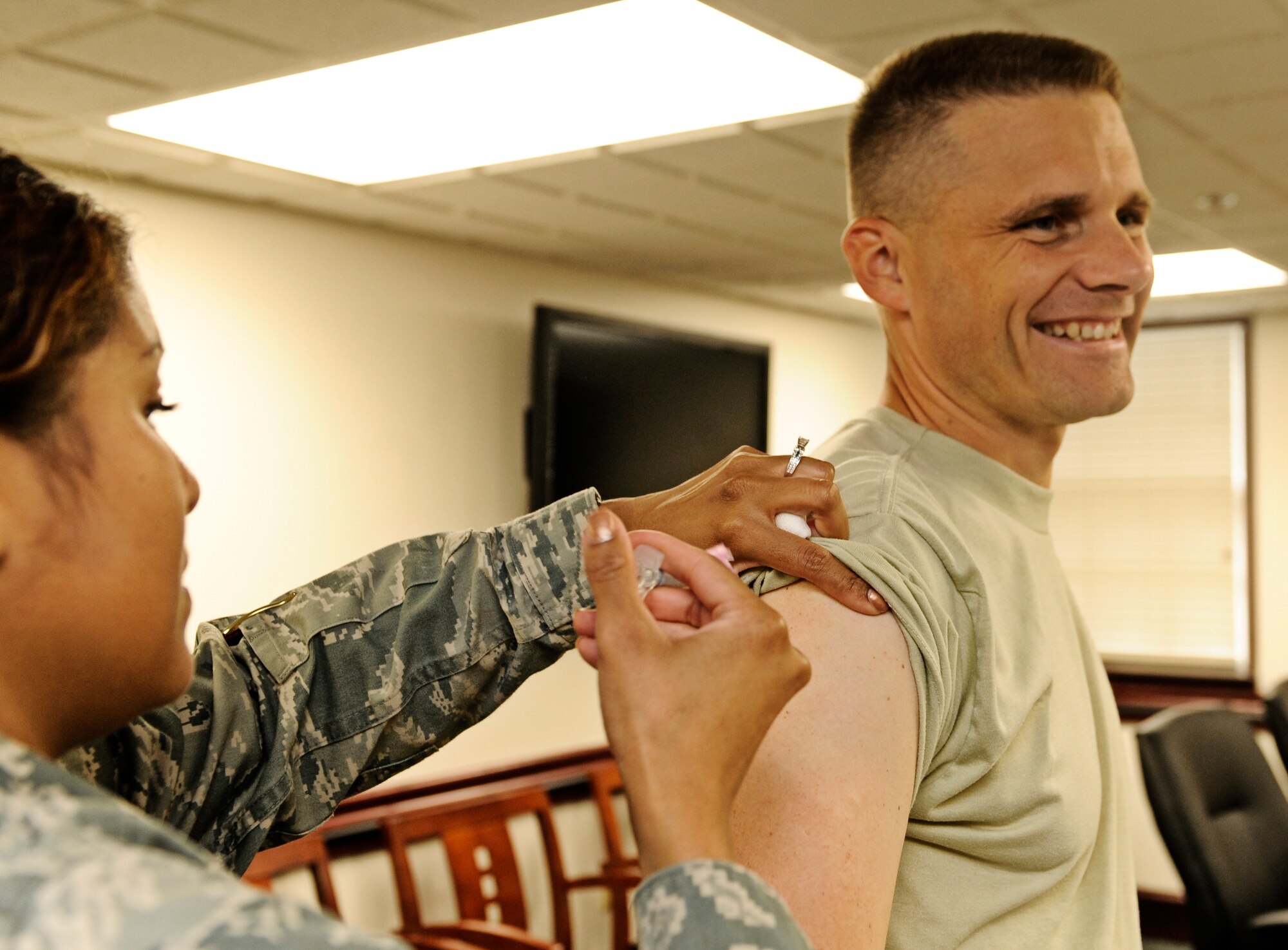 SCOTT AIR FORCE BASE, Ill. - Staff Sgt. Yelena Enos, 375th Medical Operations Squadron medical technician, administers a seasonal influenza and H1N1 vaccine to Col. Michael Hornitschek, 375th Air Mobility Wing commander, Sept. 24. (U.S. Air Force photo/Staff Sgt. Ryan Crane)