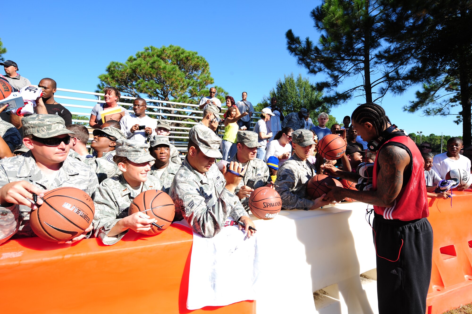 Udonis Haslem, a Miami HEAT player, signs autographs for fans before heading into practice during the Miami HEAT 2010 Training Camp at the Aderholt Fitness Center, Hurlburt Field, Fla., Sept. 29, 2010. This is the first time in 23 years the HEAT has taken their training camp on the road.  Hurlburt Field will play host to the team’s contingent of 44 from Sept. 28, through Oct. 3, 2010.  Players and staff have allotted time throughout the week to visit with Air Commandos at different work centers across base. (DoD Photo by Staff Sgt. Stephanie Jacobs/RELEASED)
