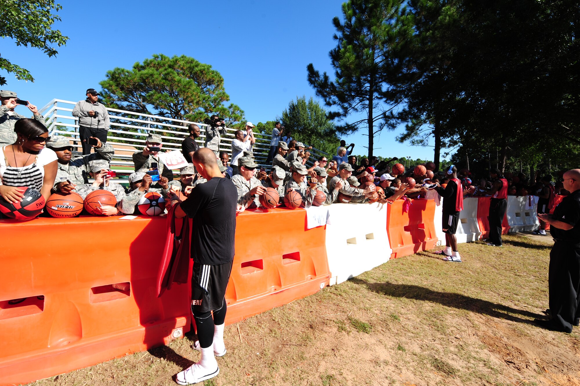 Members of the Miami HEAT team sign autographs for fans before heading into practice during the Miami HEAT 2010 Training Camp at the Aderholt Fitness Center, Hurlburt Field, Fla., Sept. 29, 2010. This is the first time in 23 years the HEAT has taken their training camp on the road.  Hurlburt Field will play host to the team’s contingent of 44 from Sep. 28, through Oct. 3, 2010.  Players and staff have allotted time throughout the week to visit with Air Commandos at different work centers across base. (DoD Photo by Staff Sgt. Stephanie Jacobs/RELEASED)
