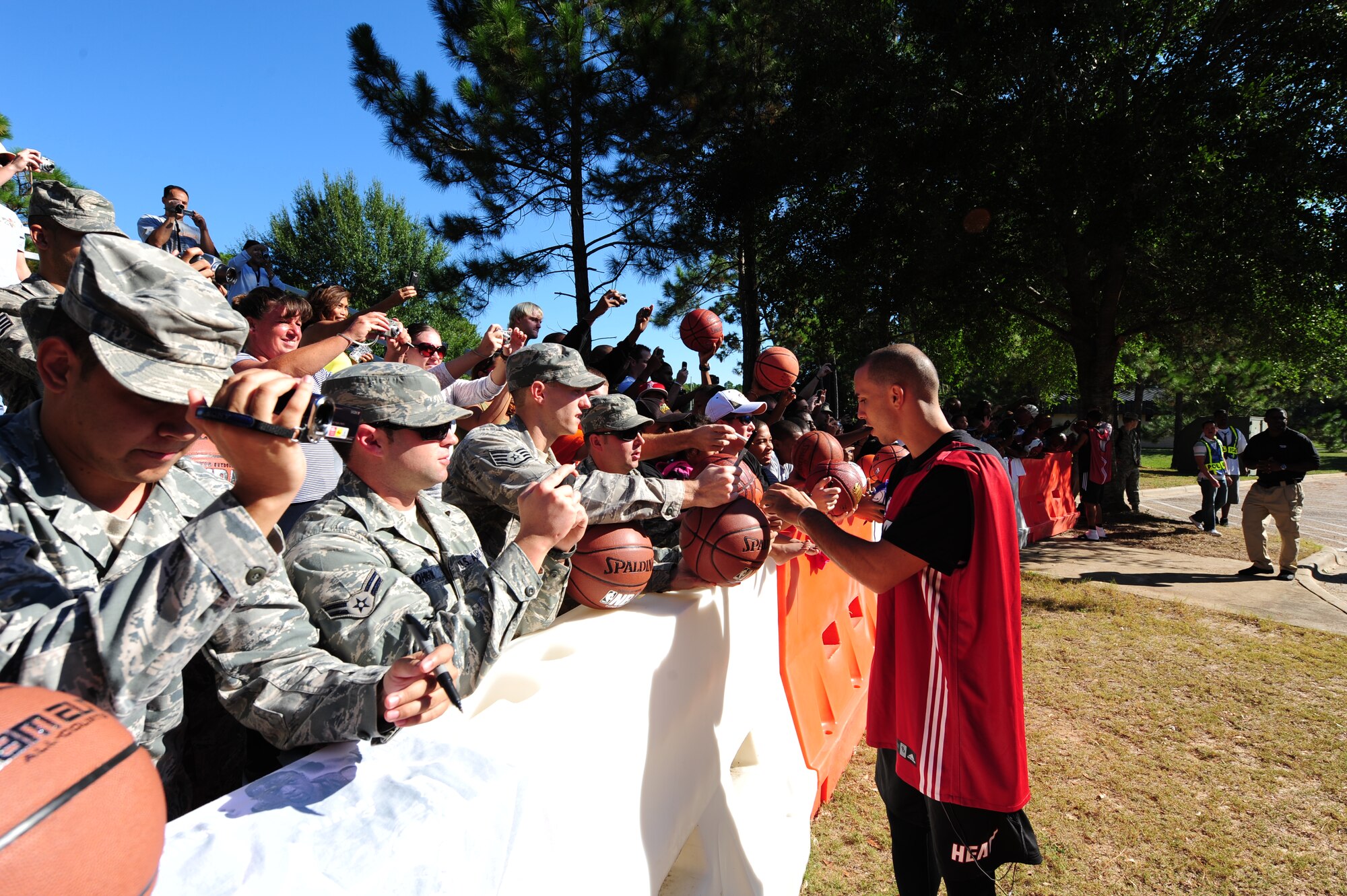 Carlos Arroyo, a Miami HEAT player, signs autographs for fans before heading into practice during the Miami HEAT 2010 Training Camp at the Aderholt Fitness Center, Hurlburt Field, Fla., Sept. 29, 2010. This is the first time in 23 years the HEAT has taken their training camp on the road.  Hurlburt Field will play host to the team’s contingent of 44 from Sep. 28, through Oct. 3, 2010.  Players and staff have allotted time throughout the week to visit with Air Commandos at different work centers across base. (DoD Photo by Staff Sgt. Stephanie Jacobs/RELEASED)
