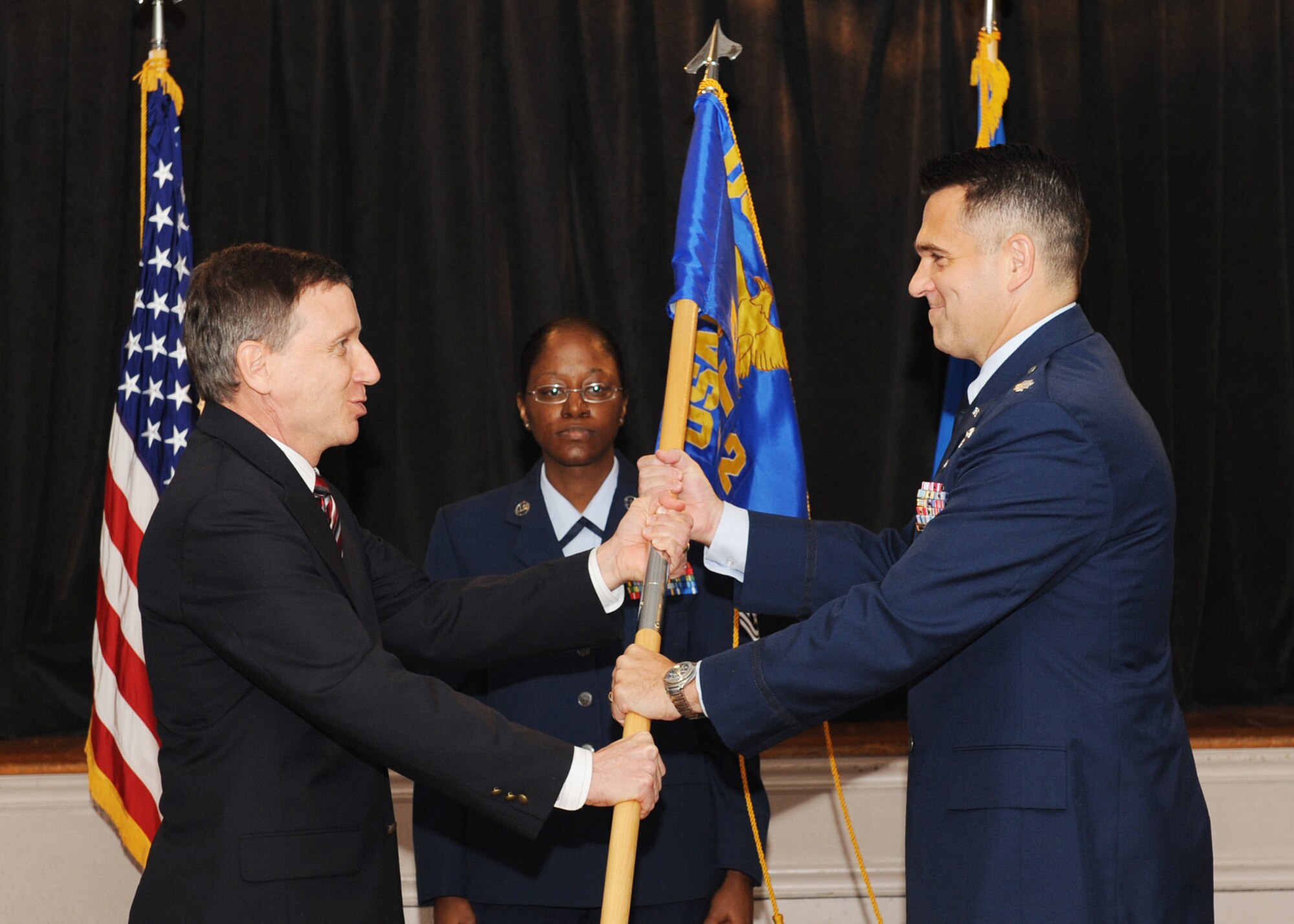 SCOTT AIR FORCE BASE, Ill. - Ruby Becker, U.S. Air Force Expeditionary Center Mobility Operations School, Detachment 2 director, passes the detachment’s guidon to Lt. Col. Joseph Davisson, Det. 2’s new commander, as Master Sgt. Cynthia Duffey, Det. 2 superintendent, watches. Colonel Davisson assumed command from Lt. Col. Wallace Kost Sept. 24 at Rockwell Hall. (U.S. Air Force photo/Senior Airman Tristin English)