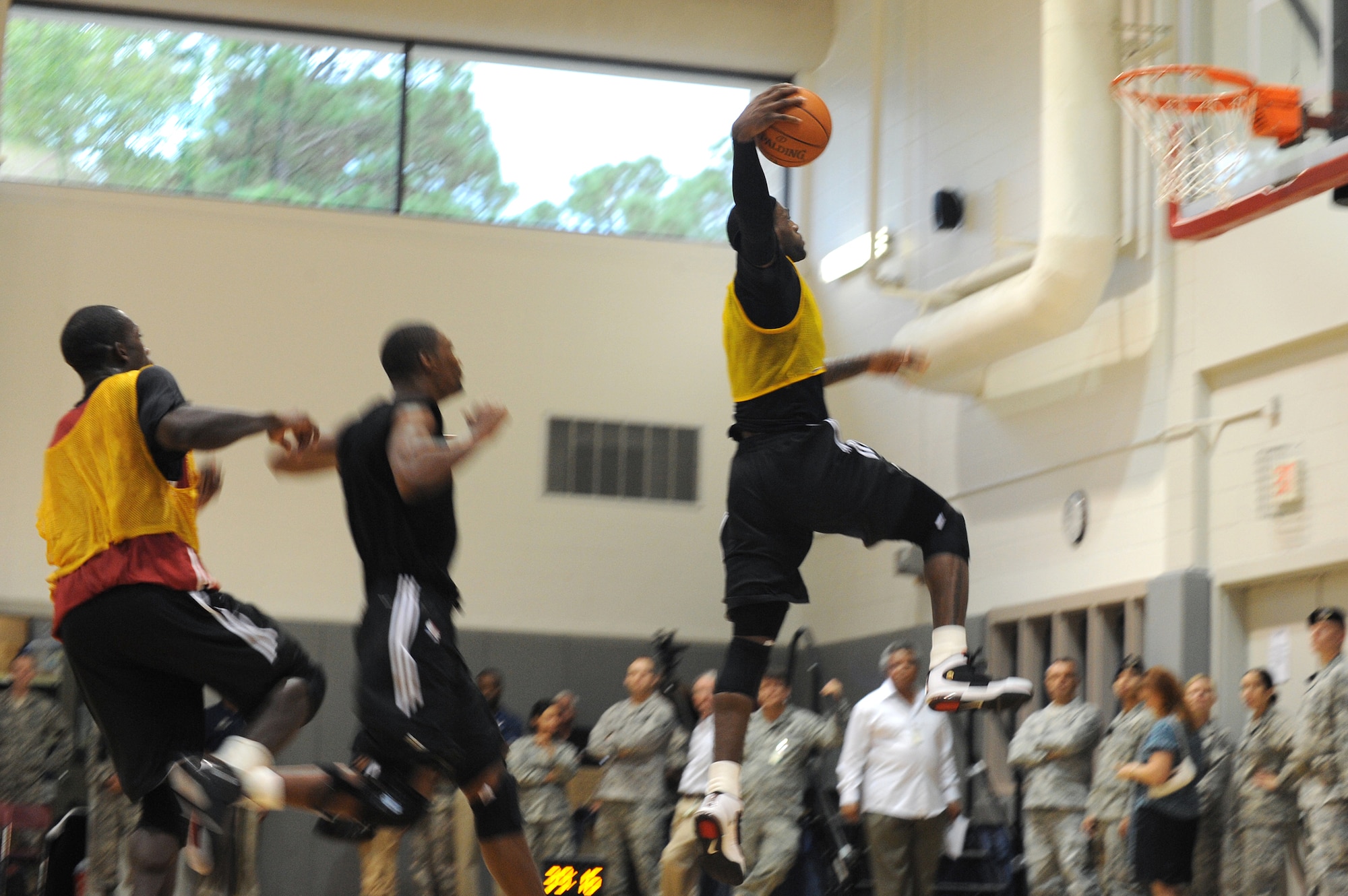LeBron James (right) prepares to dunk a basketball as fellow teammates Dwyane Wade (left) and Chris Bosh (center) watch during a preseason practice session Sept. 28, 2010, at the Aderholt Fitness Center at Hurlburt Field, Fla. The team will use the fitness center for their week-long training camp. Wade, James and Bosh are professional basketball players with the Miami Heat. (U.S. Air Force photo/Senior Airman Sheila deVera)
