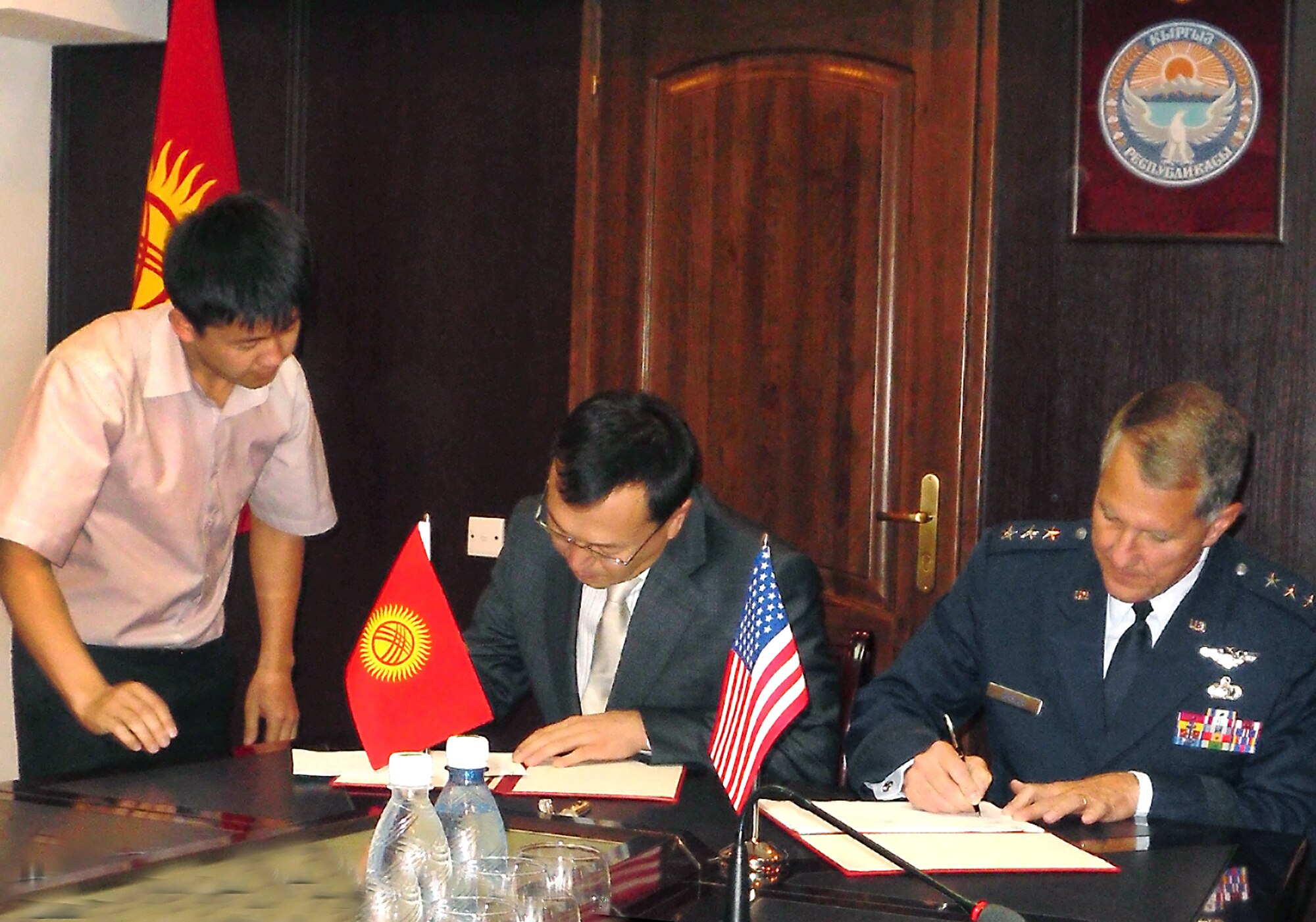 Air Force Electronic Systems Center Commander Lt. Gen. Ted Bowlds and Kyrgyzstan Transportation Minister Erkin Isakov sign an agreement Sept. 21, 2010, that defines the scope of a critical foreign military sales effort in Kyrgyzstan. The work will provide the foundation for a robust air traffic control system here. (Courtesy photo)