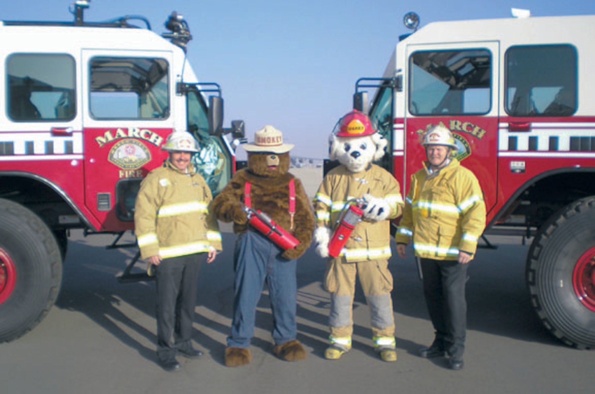 March Fire Chief Jeffrey Konersman (right) and Assistant Chief of Prevention Harold Sterne (left), prepare for Fire Prevention week by posing for a photo with Smokey, Sparky and two fire engines at the March Air Reserve Base Fire Department, Sept. 27, 2010.  (U.S. Air Force photo/ Timothy Williams)
