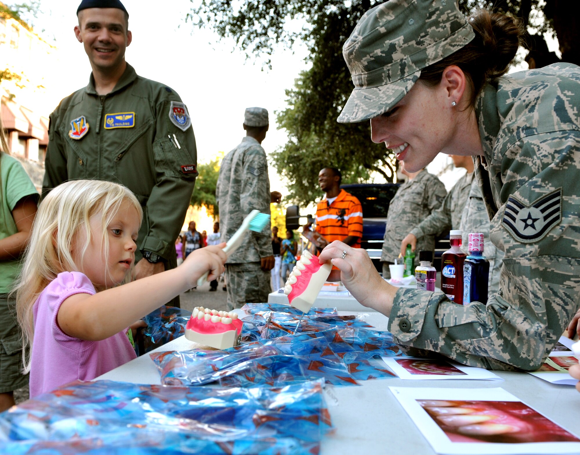 100924-F-4406D-044 SHAW AIR FORCE BASE, S.C.- Anna Hope shows Staff Sgt. Tanya Collett 20th Dental Squadron dental assistant how she brushes her teeth, downtown Sumter, S.C., Sept. 24, 2010. The Street Fest was a salute to all members stationed at Shaw AFB, Progress Energy, Federal Trade Commission and the City of Sumter.  (U.S. Air Force photo/Airman 1st Class Tabatha L. Duarte (Released)