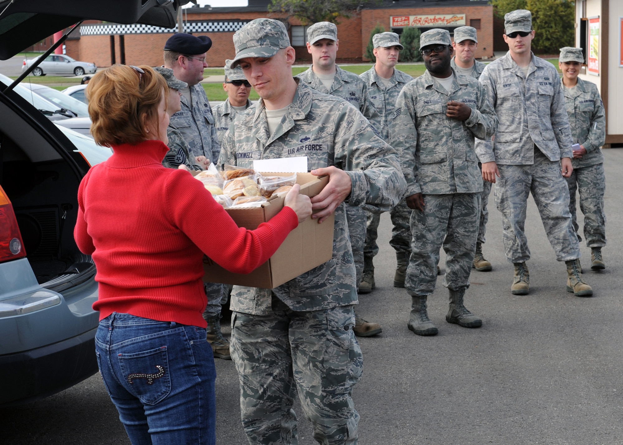 MINOT AIR FORCE BASE, N.D. -- Mrs. Deborah Wakefield, wife of Lt. Col. James Wakefield, 742nd Missile Squadron director of operations, hands a box of cookies to Staff Sgt. Lucian Rockwell, 5th Maintenance Operations Squadron defense analyst, and other volunteers to distribute to dorm residents here Sept. 24. A local Minot church donated cookies to Air Force Global Strike Command Airmen living in base dormitories. Such donations only strengthen relations between the base and its surrounding communities. (U.S. Air Force photo by Staff Sgt. Keith Ballard)