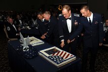 MINOT AIR FORCE BASE, N.D. -- Col. Fred Stoss , 91st Missile Wing commander, and Airman 1st Class Robert Lease, 742nd Missile Squadron missile chef, alongside Col. Douglas Cox, 5th Bomb Wing commander, and Airman Darren Zabinski, 5th Logistics Readiness Squadron traffic management apprentice, take part in cutting the cake in celebration of the Air Force birthday at the Air Force Ball held in the Jimmy Doolittle here Sept. 25. A sword is used to cut the cake as a reminder to Air Force Global Strike Command Airmen that they are a band of warriors who have answered their nation’s call, committed to carrying her sword and shield so all may live in peace. (U.S. Air Force photo by Airman 1st Class Aaron-Forrest Wainwright)