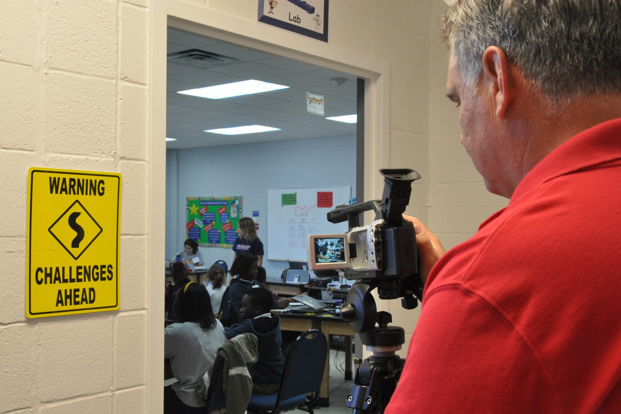 Greg Steele, visual information specialist for the 917th Wing, videotapes Ms. Laurie Ilgenfriz, in a STARBASE classroom as she explains to a group of 5th Graders how to figure the mass of an object, Sept. 28, 2010. Ms. Ilgenfriz is a program instructor. STARBASE Louisiana recently completed more than 10 years of service, graduating more than 10,000 students. The facilities have recently been upgraded, and the Grand Reopening event will be held on Oct. 18, 2010, at the STARBASE facility to celebrate and showcase the benefits of STARBASE and its history of support from the educational, military, and corporate communities, and its proven track record of raised student performance and increased interest in S.T.E.M. subjects. (U.S. Air Force photo/Tech. Sgt. Jeff Walston) 

