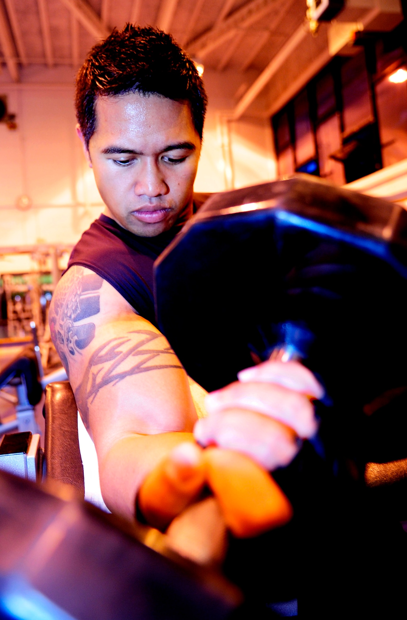 RAF MILDENHALL, England -- Staff Sgt. Reggie Patterson, 100th Logistics Readiness Squadron, performs sets of curls at the North Side Fitness Center here Sept. 23. Doing curls is just one of many exercises that can be done to strengthen you upper body and keep you fit. (U.S. Air Force photo/Senior Airman Ethan Morgan)