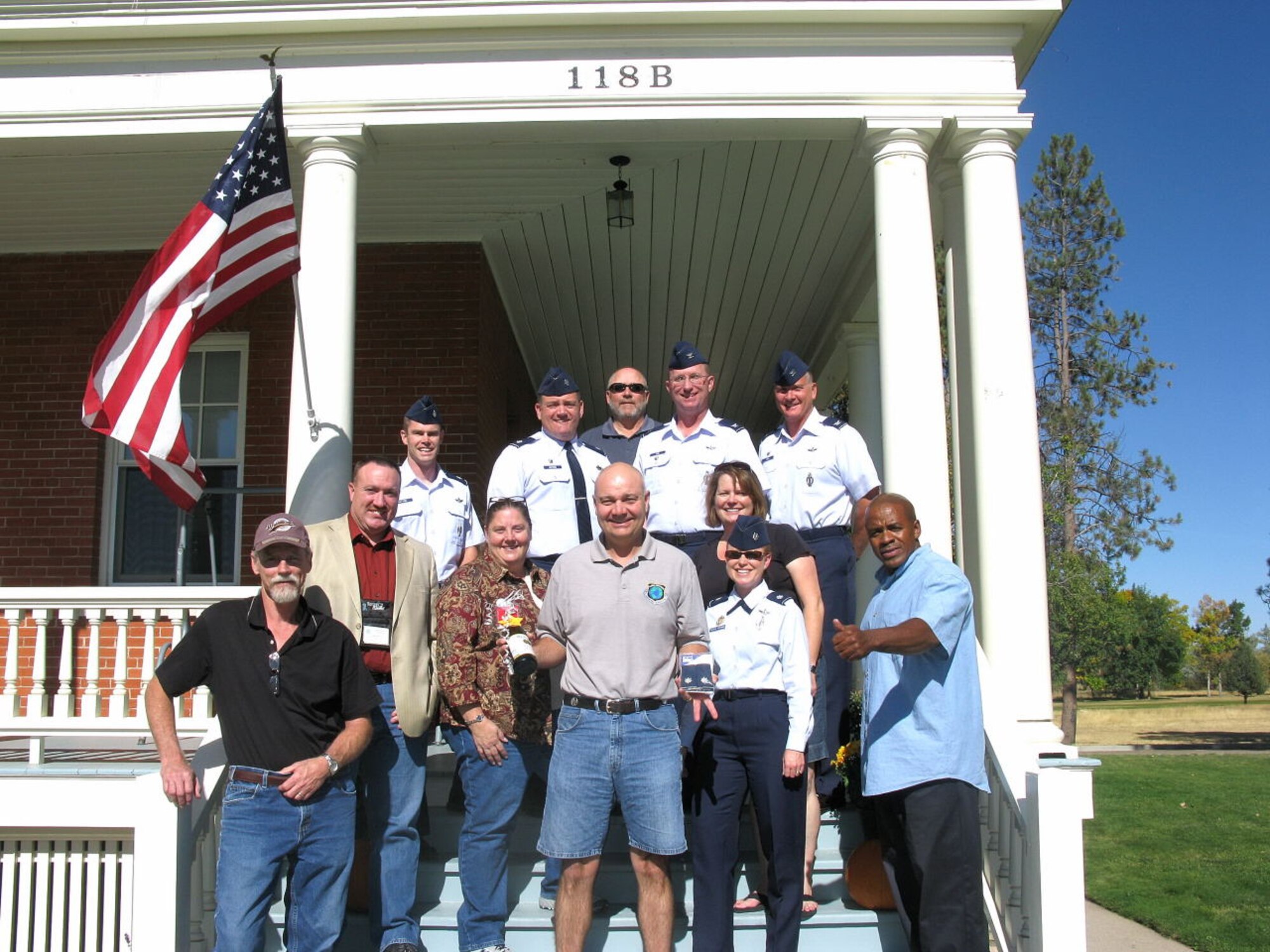 Col. Greg Tims, 90th Missile Wing commander, and Col. Scott Fox, 90th MW vice commander, along with other members of the 90th MW staff made a surprise visit at the home of 90th MW Wing Chaplain Maj. Alan "AC" Chouest on Sept. 27 to notify him of his selection to lieutenant colonel. Colonel Tims says, "Traditions like these are what make our Air Force life great!" (U.S. Air Force photo by Julie Tims)