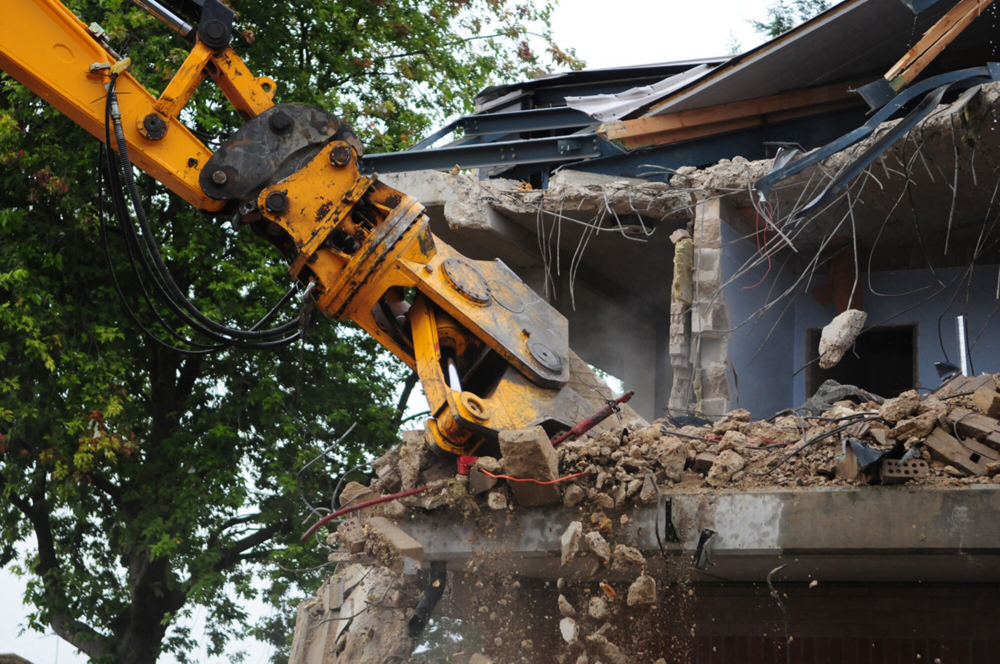 RAF MILDENHALL, England -- A mechanical digger tears apart concrete supports and brick walls which were part of dormitory 212 Sept. 23. The quality of the Airmen's quarters had deteriorated and had become surplus to requirements. Once demolition is complete, which is scheduled for January 2011, the area will be landscaped. (U.S. Air Force photo/Karen Abeyasekere)