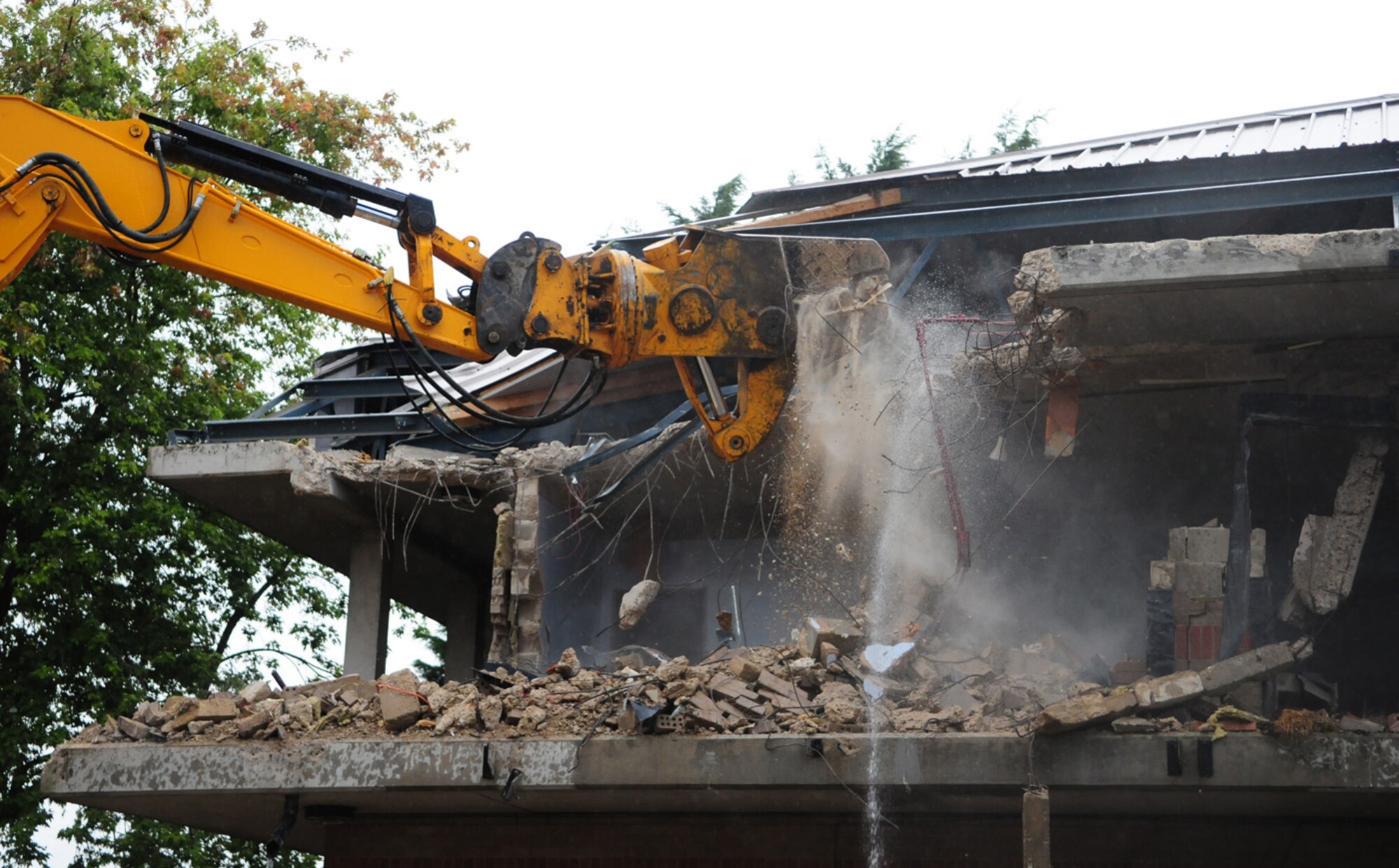 RAF MILDENHALL, England -- Like a dinosaur munching down food, a mechanical digger rips apart Dorm 212 as part of an ongoing demolition project. The quality of the Airmen's quarters had deteriorated and had become surplus to requirements. Once demolition is complete, which is scheduled for January 2011, the area will be landscaped. (U.S. Air Force photo/Karen Abeyasekere)