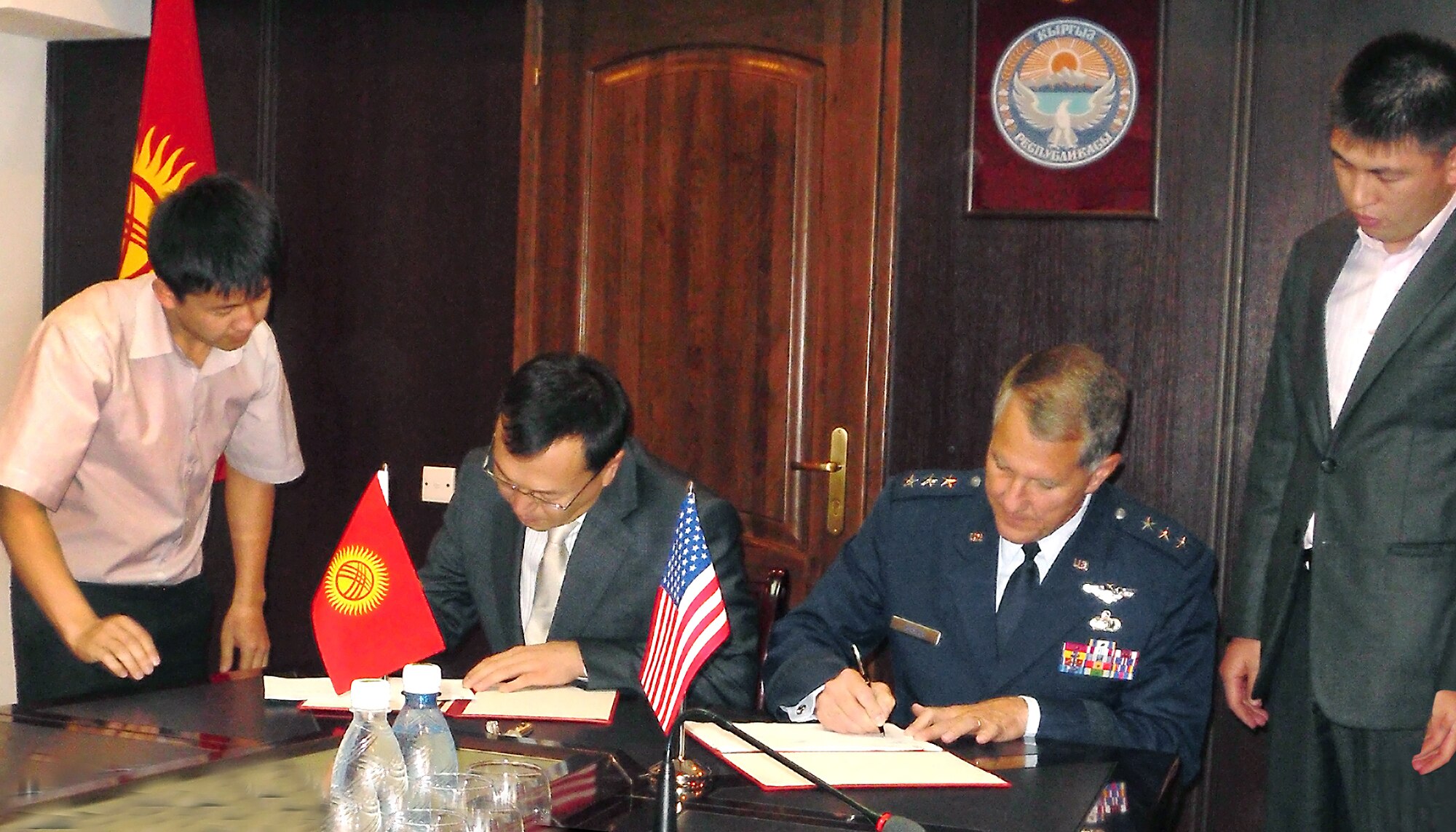 Air Force Electronic Systems Center Commander Lt. Gen. Ted Bowlds and Kyrgyzstani Transportation Minister Erkin Isakov sign an agreement Sept 21 that defines the scope of a critical foreign military sales effort in Kyrgyzstan.  The work will provide the foundation for a robust air traffic control system there.  (Courtesy Photo)