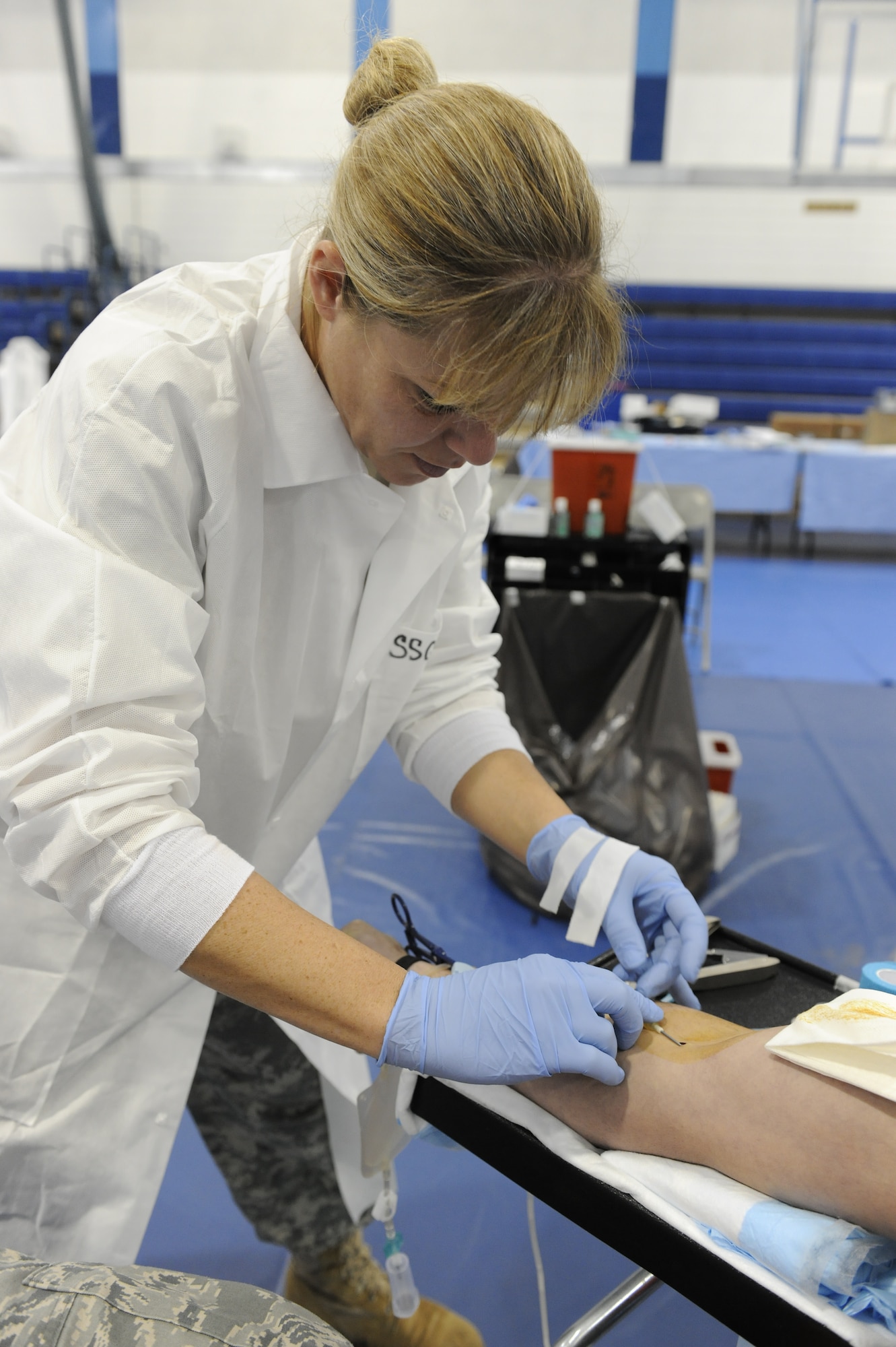 ROYAL AIR FORCE LAKENHEATH, England -- Army Staff Sgt. Sylvia Sacco, United States Army Europe Blood Donor Center mobile team NCO in charge, inserts an IV in preparation to draw blood from Airman 1st Class Scott Schreiber, 48th Maintenance Operations Squadron analyst, during the Armed Services Blood Program held at the fitness center Sept. 27. The donation process takes approximately 45 minutes to an hour involving several stations to include registration, physical exam and actual collection of blood. (U.S. Air Force photo/Airman 1st Class Lausanne Morgan)