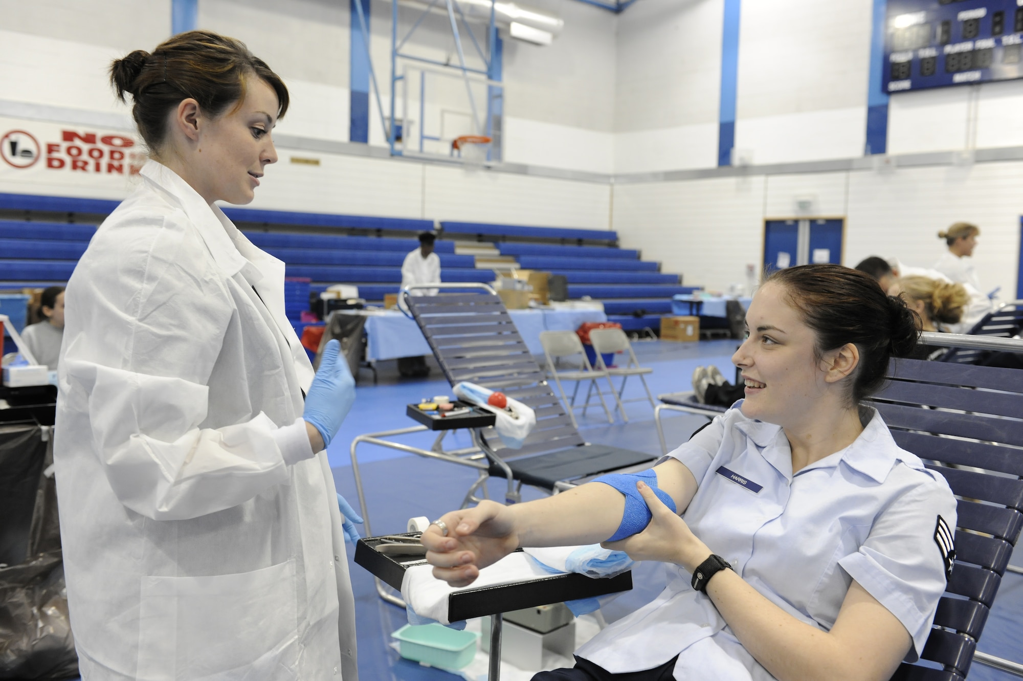 ROYAL AIR FORCE LAKENHEATH, England -- Autumn Rosa, United States Army Europe Blood Donor Center Laboratory technician, informs Senior Airman Julie Harris, 48th Medical Logistics Squadron Laboratory technician, on certain restrictions and precautions involved after giving blood Sept. 27, during the Armed Services Blood Program held at the fitness center. Some restrictions and precautions include drinking plenty of fluids four hours post-donation, no smoking for 30 minutes and no consumption of alcohol the day of donation. (U.S. Air Force photo/Airman 1st Class Lausanne Morgan)