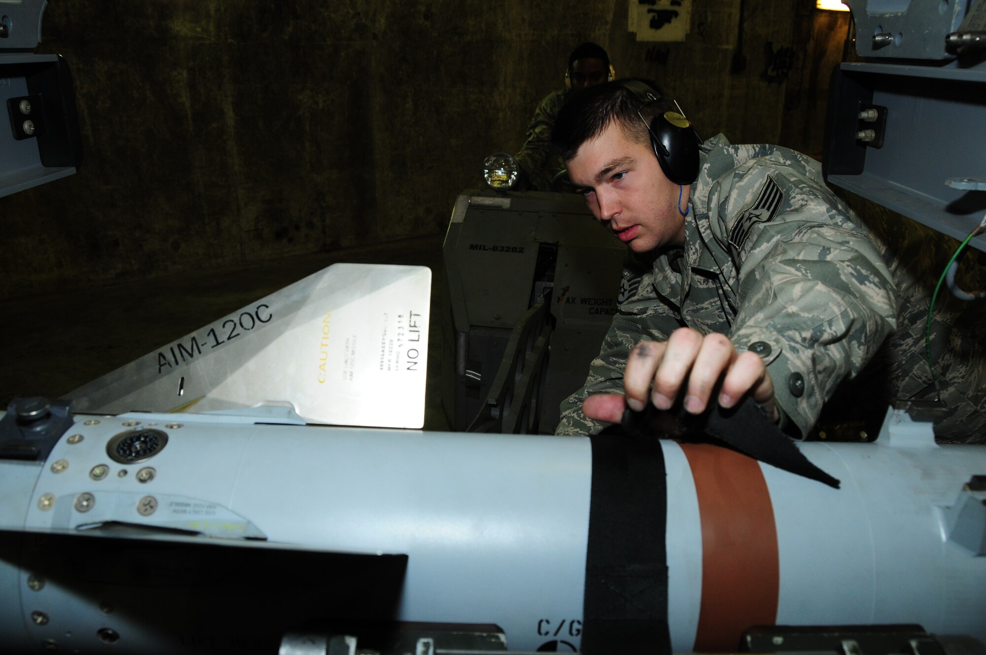 KEFLAVIK, Iceland – Staff Sgt. Ronald Townsend, 493rd Expeditionary Fighter Squadron Weapons Load Crew team chief, straps an AIM-120 Advanced Medium-Range Air-to-Air Missile to an MJ-1, a vehicle specially made to load munitions, being driven by Senior Airman Jonathan Ard, 493rd EFS, Sept. 23. (U.S. Air Force photo/Senior Airman Stephen Linch)