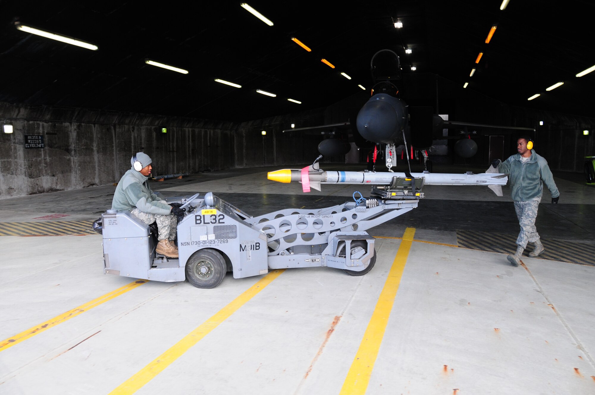 KEFLAVIK, Iceland – Staff Sgt. Eric Venter (right), 493rd Expeditionary Fighter Squadron Weapons Load Crew team chief, guides an AIM-9X missile that is loaded on an MJ-1, a vehicle specially made to load munitions, being driven by Senior Airman Marquell Stalling, 493rd EFS Weapons Load Crew team member, Sept. 23. Sergeant Venter and Airman Stallings are deployed from the 748th Aircraft Maintenance Squadron at RAF Lakenheath, England. (U.S. Air Force photo/Senior Airman Stephen Linch)