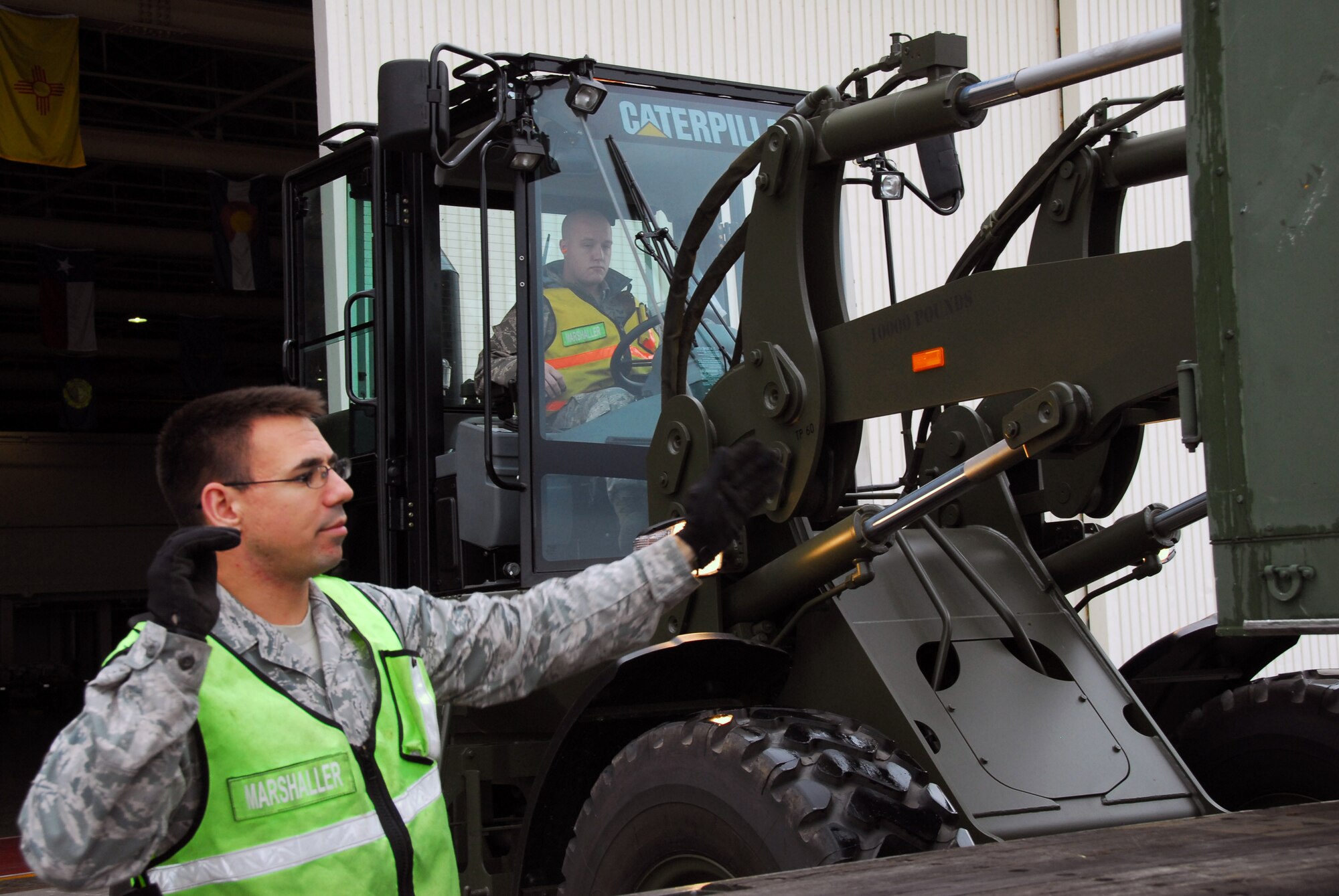 Airman 1st Class James Nichols (left), 35th Logistics Readiness Squadron, marshals Staff Sgt. Jacob Showalter, 35th LRS, who drives a forklift carrying equipment at Misawa Air Base, Japan, Sept. 24, 2010. Cargo is inspected by Misawa’s cargo deployment function, ensuring packaged products comply with regulations. (U.S. Air Force photo by 1st Lt. Cammie Quinn/ Released)  