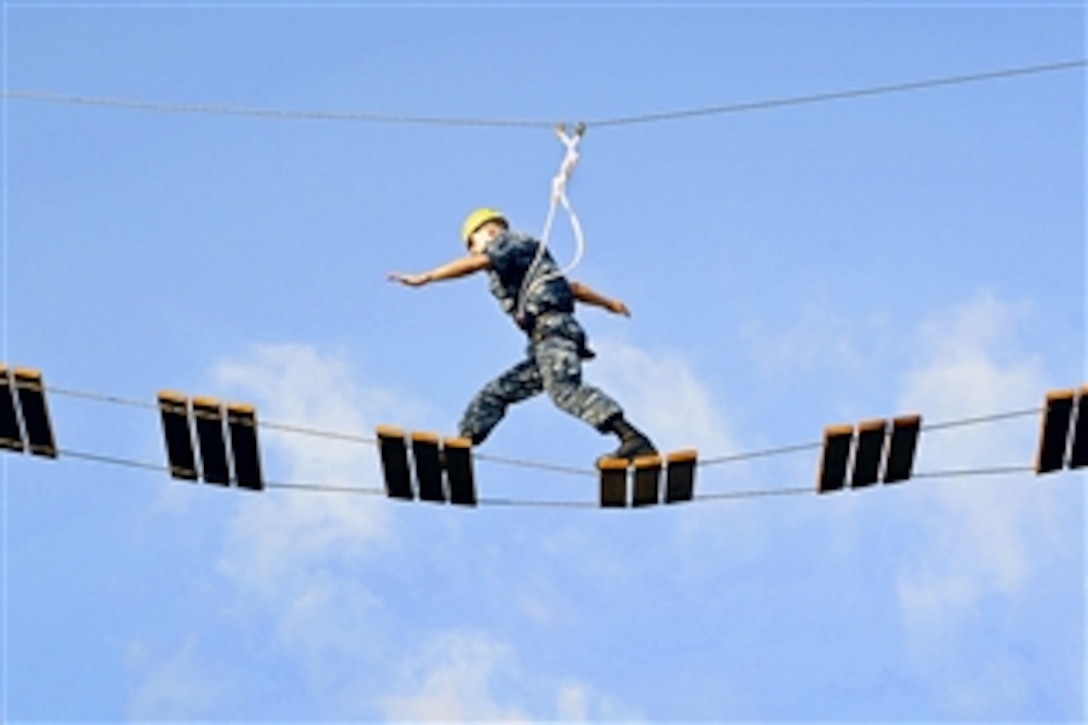 U.S. Navy Officer Candidate Shaun Penrod crosses a portion of the new, 39-foot-tall high ropes on Naval Station Newport, R.I., Sept. 22, 2010. Officer candidates are required to complete the course before graduating from Officer Candidate School and being commissioned.