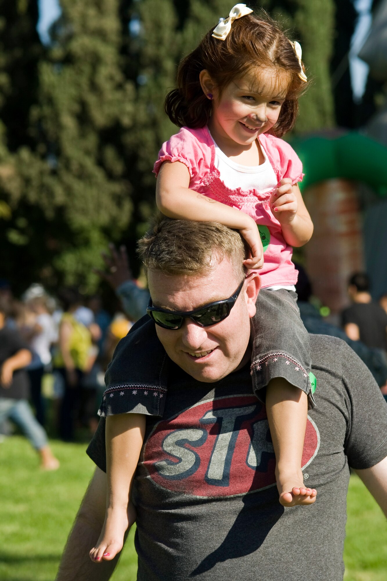 Senior Master Sgt. Keith Baxter, 4th Combat Camera Squadron, carries his daughter on his shoulders  during the 38th Annual Military Appreciation Picnic at March Air Reserve Base, Calif., Sept. 18. (U.S. Air Force photo by Tech. Sgt. Efren Lopez)