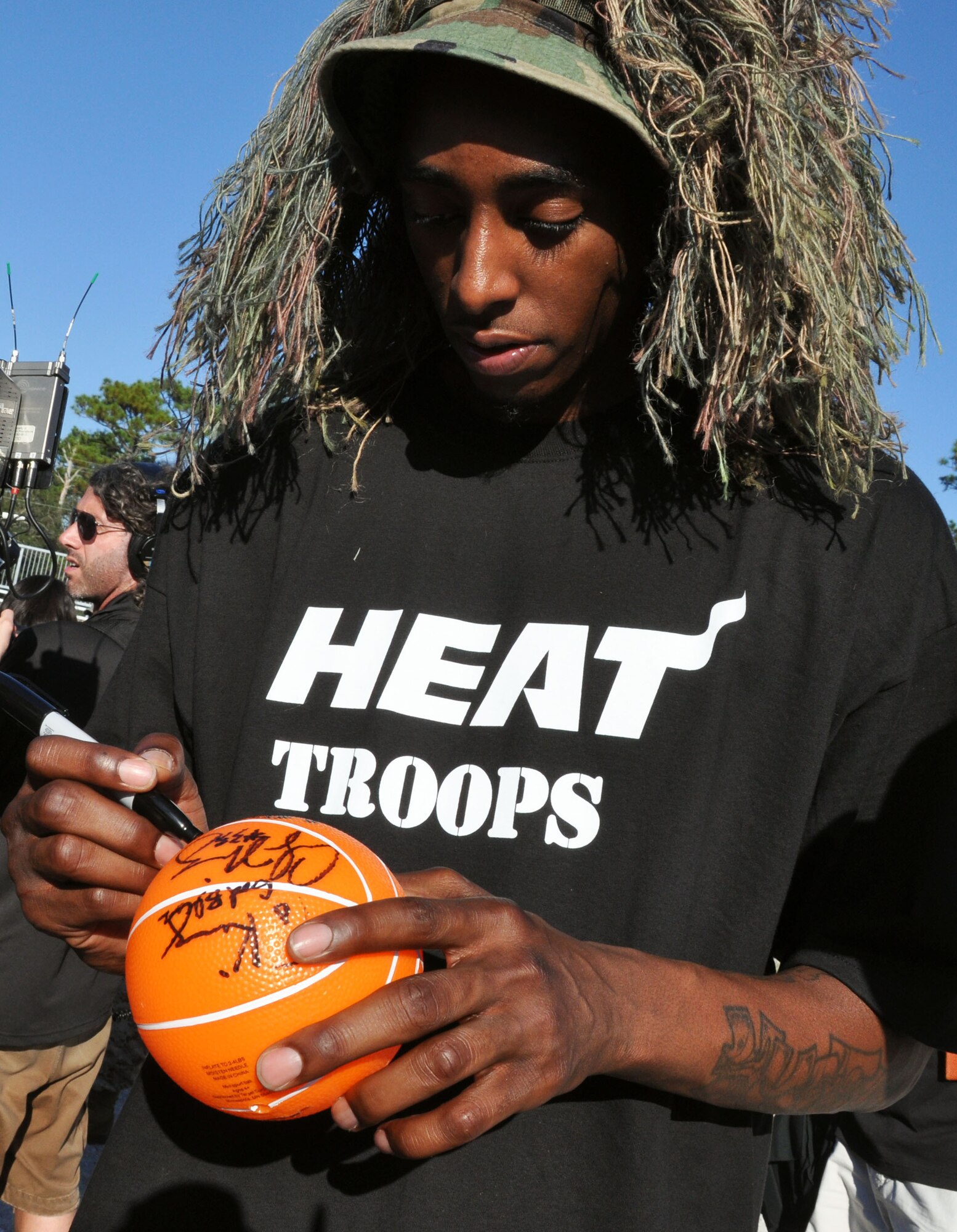 The Miami Heat's Anthony Mason, in sniper garb, signs a basketball for a fan after Airmen from the 96th Ground Combat Training Squadron conducted an urban warfare scenario Sept 30 here. (U.S. Air Force photo/Staff Sgt. Stacia Zachary)