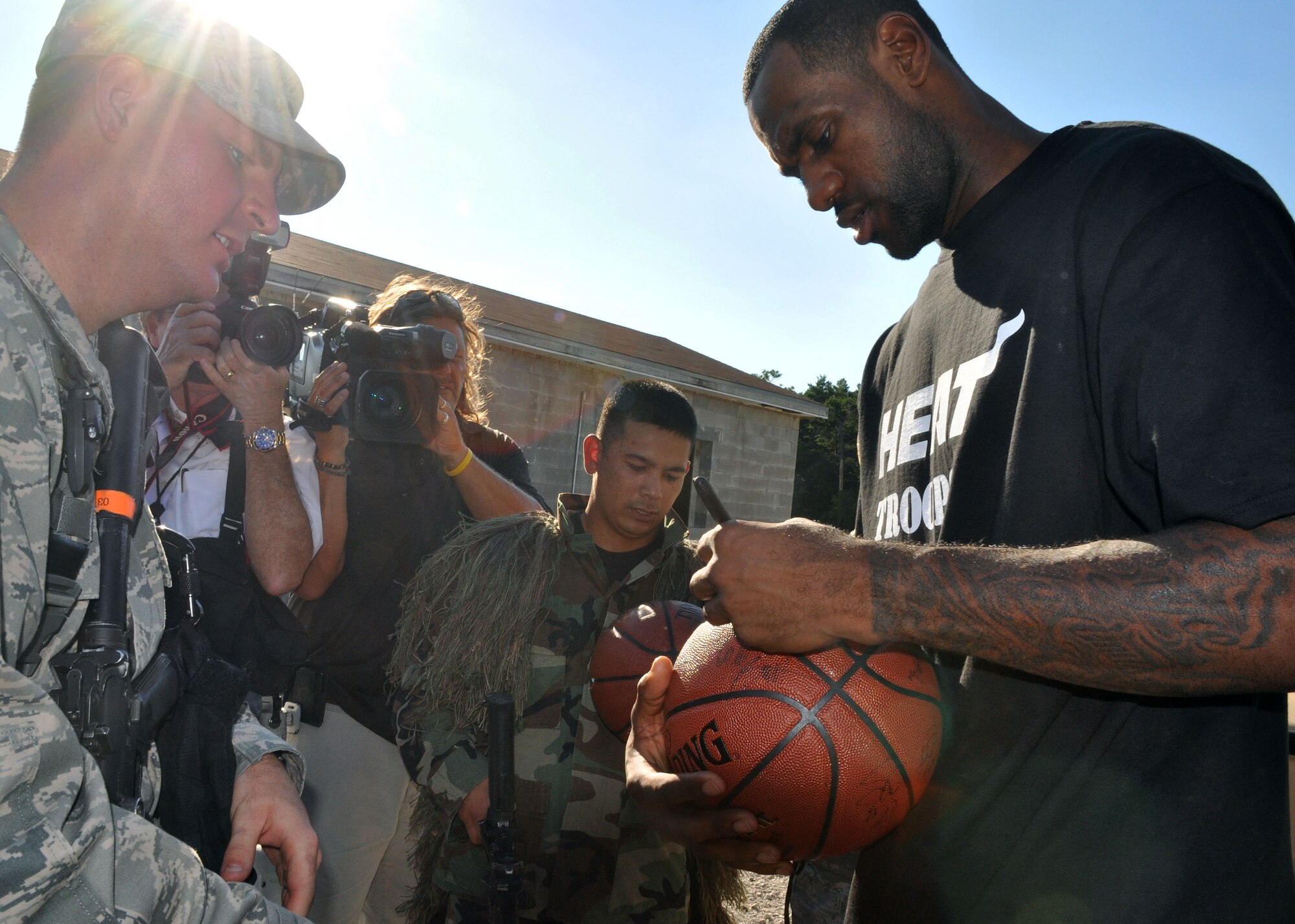 The Miami Heat's LeBron James signs a basketball for an Airman at the 96th Ground Combat Training Squadron following an urban warfare scenario was performed Sept. 30 here. (U.S. Air Force photo/Staff Sgt. Stacia Zachary)