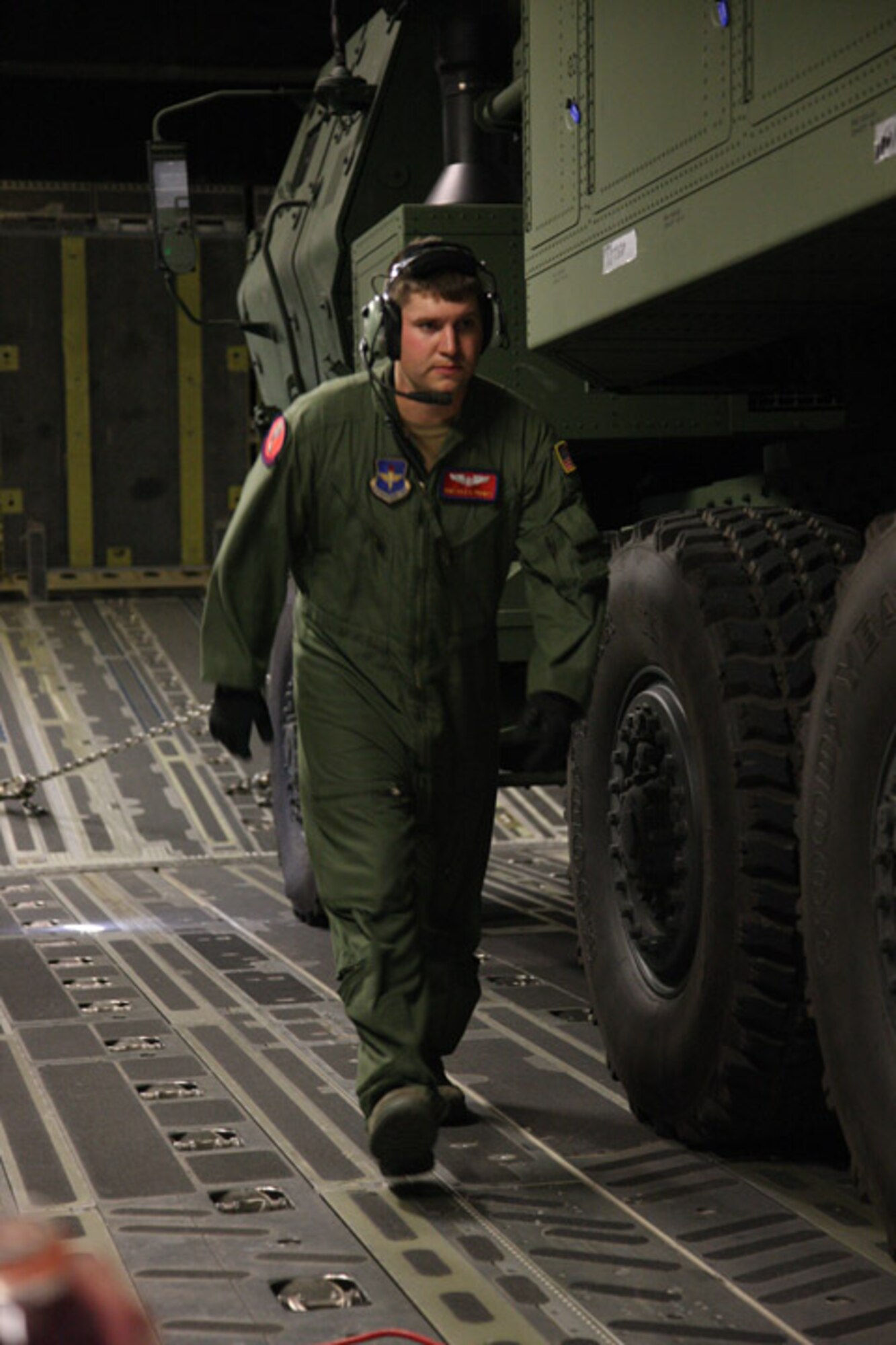 Staff Sgt. Kyle Prewitt, 58th Airlift Squadron, walks up an incline inside a C-17 from Altus AFB that is gaining altitude over Fort Sill Sept. 16. The flight was to test an upgrade on the fire control system on a High Mobility Artillery Rocket System. The Airman did his part to make sure the chains holding the huge launchers in place had the right amount of restraint during the flight. (U.S. Army photo by Marie Berberea)