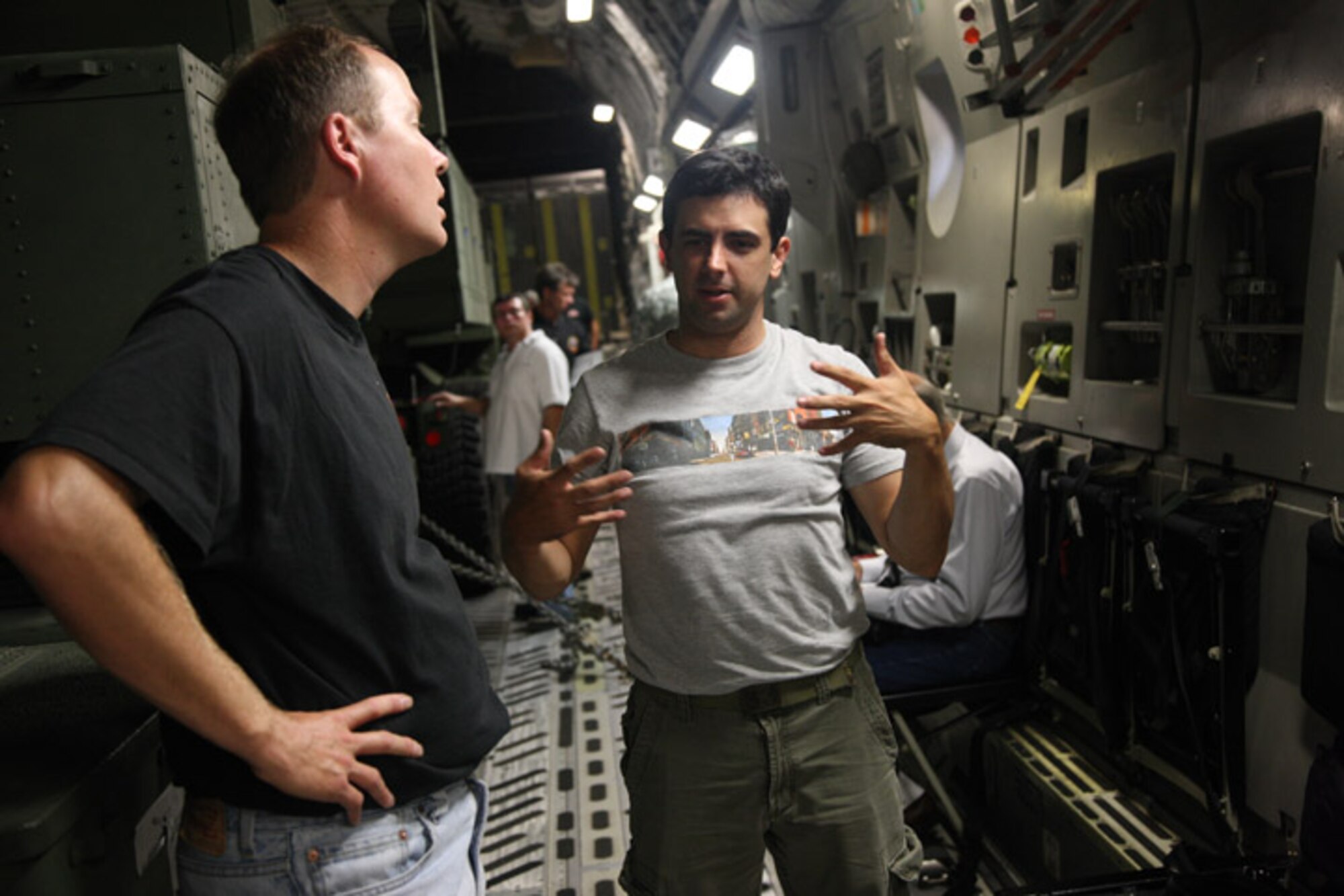 Robert Miller, Techmasters navigation engineer, discusses how the signal from the re-transmitters on the C-17 from Altus AFB are sent to the receivers on the High Mobility Artillery Rocket System to James Cyr, Precision Fires Rocket and Missile System. The pair were part of a large group testing an upgrade to the fire control system aboard the launchers Sept. 16. (U.S. Army photo by Marie Berberea)