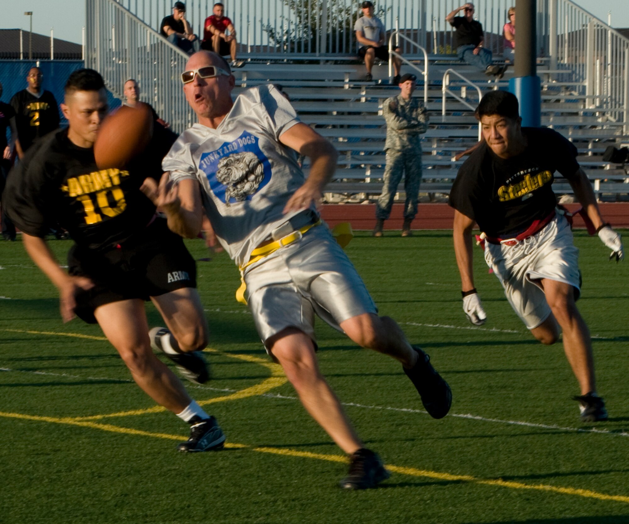 GOODFELLOW AIR FORCE BASE, Texas -- 17th Mission Support Group Junk Yard Dog quarterback, Charlie Rehburg pitches the ball to another player, as 344th Army defenders, Scott Blakey (10) and John Kong, close in- during intramural play at the base football field Sept. 27. A last second touchdown by Army tied the game at 13-13, forcing overtime. With four downs each, the Junk Yard Dogs were able to outplay Army by 23-yards, helping to secure a 1-point lead. The Dogs advanced to play Army again for the championship. (U.S. Air Force photo/ Senior Airman Tong Duong)