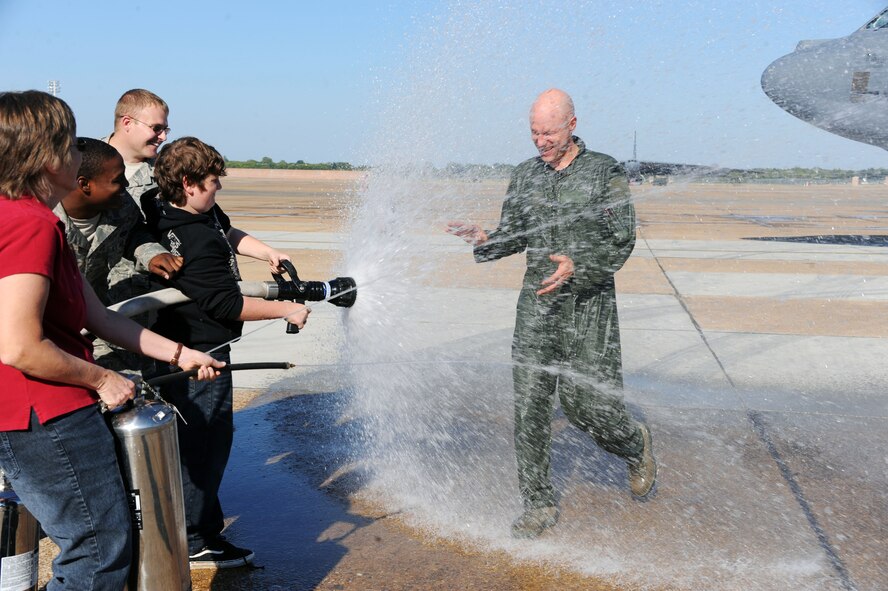 BARKSDALE AIR FORCE BASE, La. -- Col. Gregory Smith, 2nd Operations Group commander was greeted by his family hosing him down after his "fini" flight Sept. 29. It is a time honored tradition when fire trucks join the crowd in welcoming the pilot back from his final flight and hose him down with the water hose from the fire truck.  (U.S. Air Force photo/Senior Airman Brittany Y. Bateman)(RELEASED)