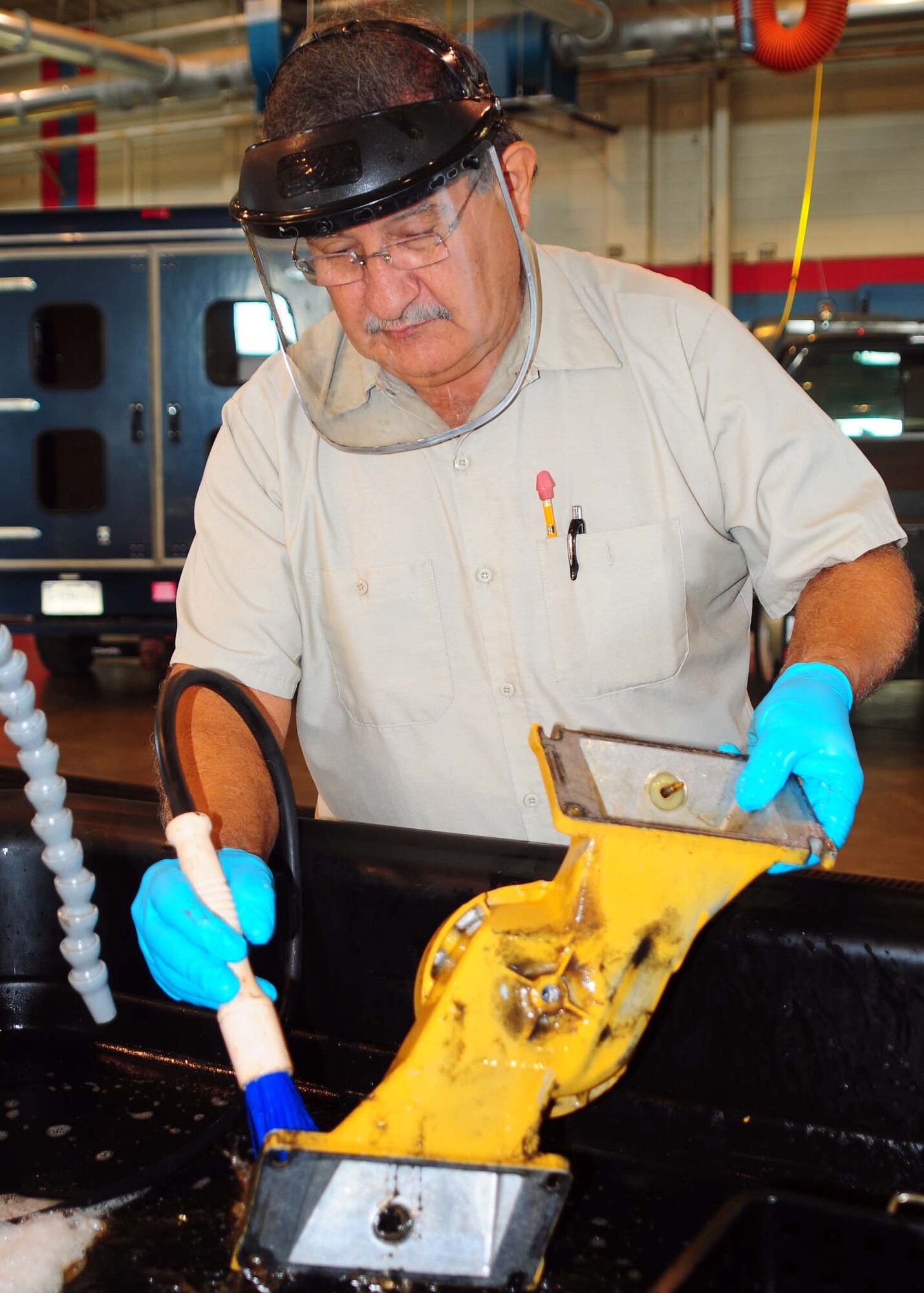 An environmentally-friendly parts washer at 97th Vehicle Maintenance is getting attention for using oil-eating microbes, which means workers are no longer exposed to the solvents previously used. “We will continue using the protective equipment, because the dirt and oil is the same.” (U.S. Air Force photo by Senior Airman Leandra D. Hernandez / Released 97th Air Mobility Wing Public Affairs)