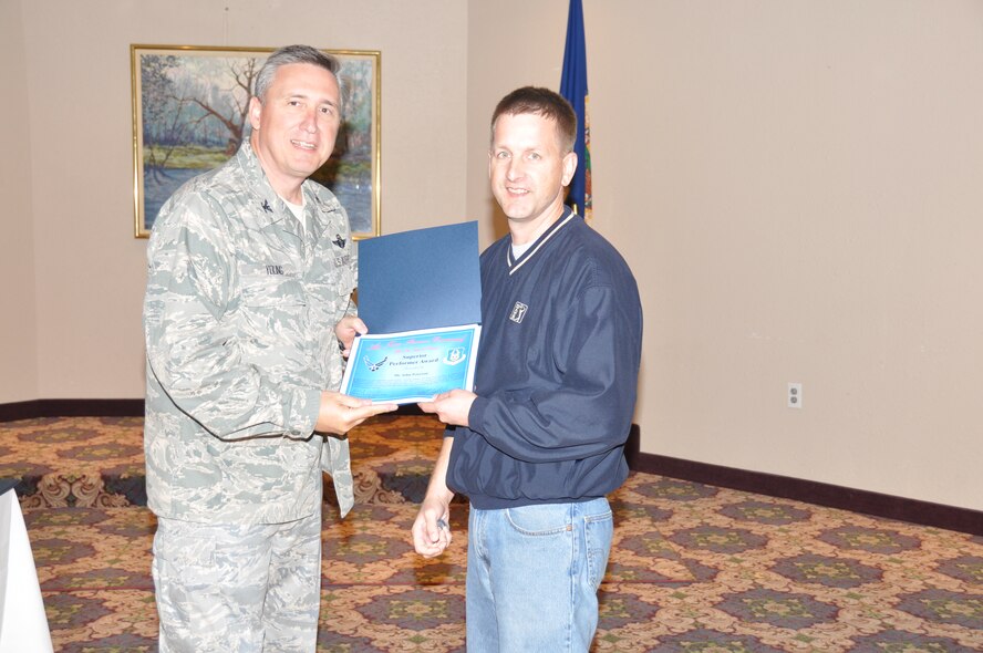 Mr. John Peterson receives his superior performer award from Col. Darrell G. Young, 934th Airlift Wing commander, at the post inspection recognition luncheon Sept. 28. (Air Force Photo/Paul Zadach)