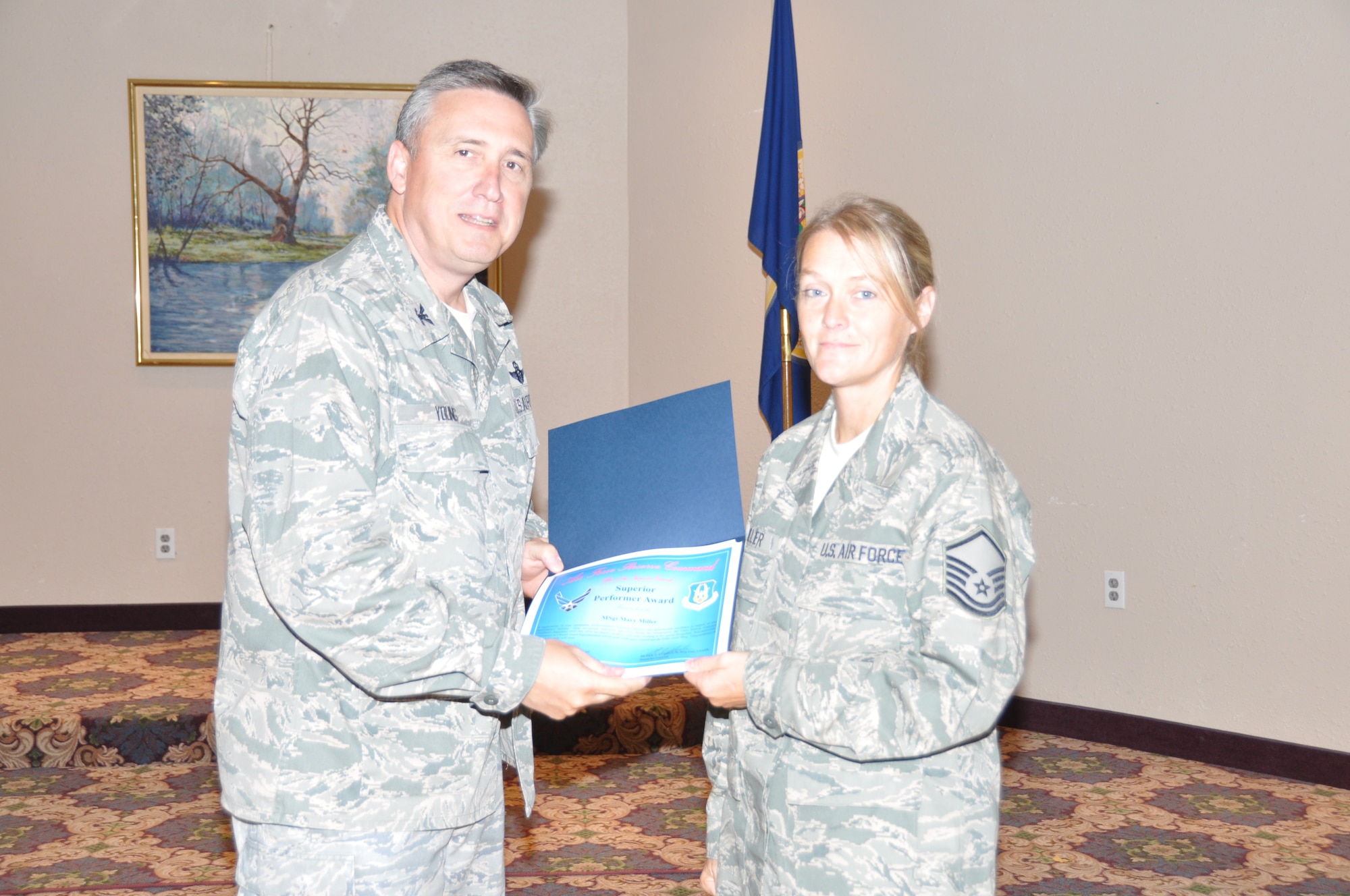 Master Sgt. Mary Miller receives her superior performer award from Col. Darrell G. Young, 934th Airlift Wing commander, at the post inspection recognition luncheon Sept. 28. (Air Force Photo/Paul Zadach)