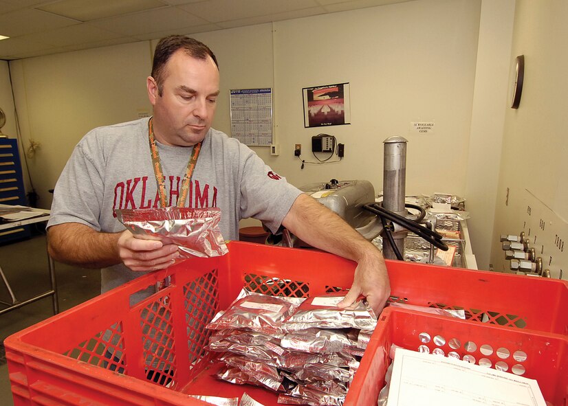 Todd Taylor works in the shipping room of the Bearing Overhaul Shop, preparing finished bearings for customers.  After cleaning and inspecting, bearings are sealed in bags to protect against the smallest contaminants.  (Air Force photo by Margo Wright)