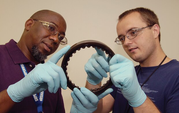 Bearing Overhaul Shop supervisor Melvin Lovings, left, and Stephen Kingham, look over a bearing assembly in the 552nd Commodities Maintenance Squadron facility located in Bldg. 3001. The 11 employees of the Level I shop identify, clean, inspect and process or condemn bearings coming from a variety of engines, missiles and other aircraft components.  (Air Force photo by Margo Wright)