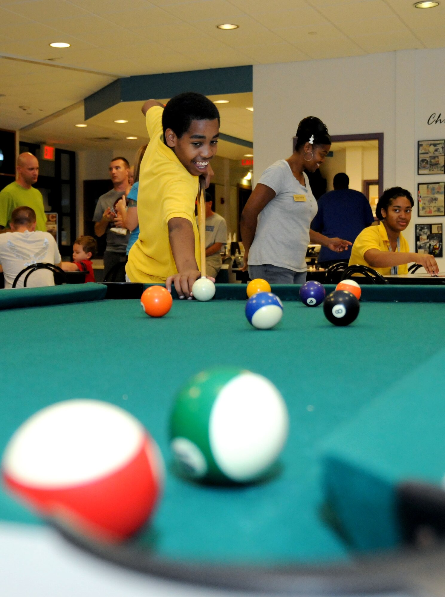 Nicholas Harvey, son of retired Staff Sgt. Rodney Harvey and Senior Airman Eleanor Harvey, a reservist in the 403rd Services Squadron and a civilian in the 81st Force Support Squadron, angles for a tricky shot during a game of pool.  (U.S. Air Force photo by Kemberly Groue)