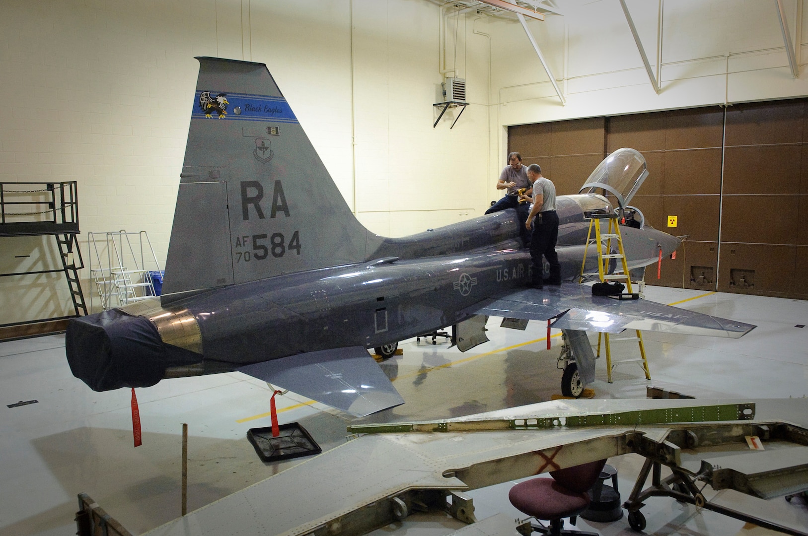 Randolph AFB, TX, 30 September 2010: Members of the 12th Flying Training maintenance directorate replace panels on a T-38 inside the lead lined inspection hangar after a nondestructive x-ray inspection.  (U.S. Air Force photo/Steve Thurow)