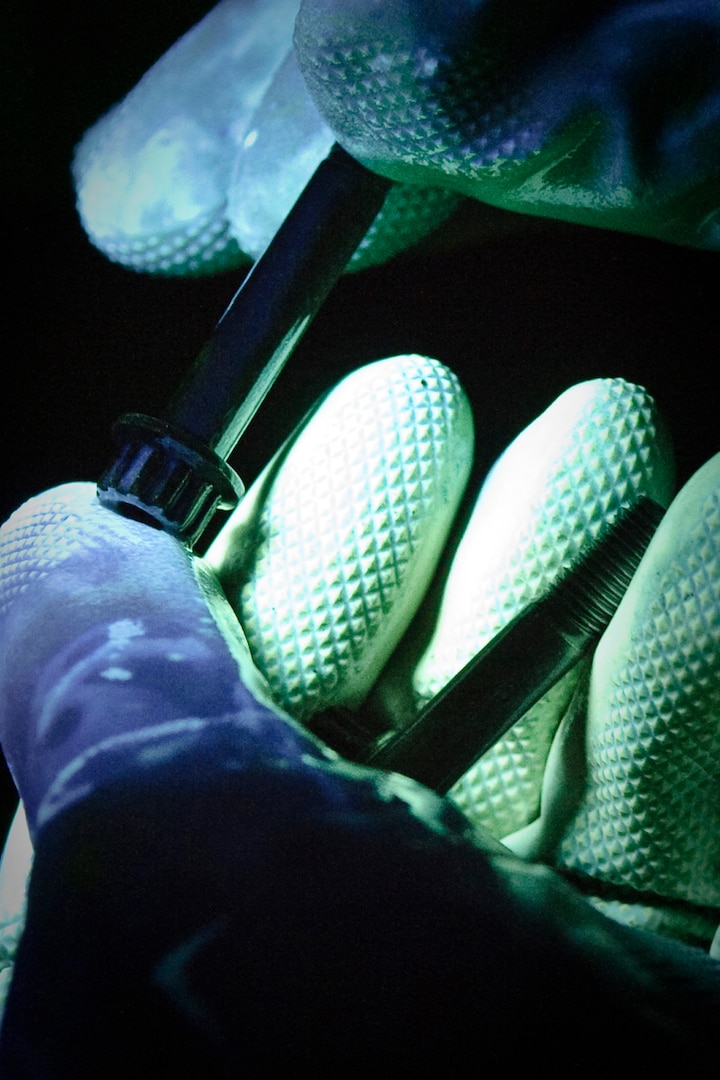 Randolph AFB, TX, 30 September 2010: The 12th Flying Training Wing maintenance directorate, nondestructive inspection shop, utilizes magnetic inspection to ensure that T-1 wheel tie bolts are free from cracks or scratches by magnetizing the object and running it under magnetic fluorescing dye before inspecting it under a black light, defects glow bright green under the light. (U.S. Air Force photo/Steve Thurow)