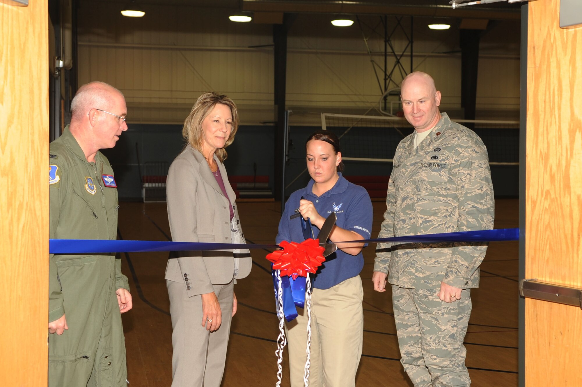 Col.  John Quinn (left), 319th Air Refueling Wing vice commander, Mary Giltner, 319th Civil Engineer Squadron (middle left), and Maj. Robert Reinhart (right), 319th Force Support Squadron commander, watch as Senior Airman Jennifer Frerichs (middle right), 319th FSS, cuts the ribbon to signify the reopening of gym two at the Fitness Center Sept. 30 Grand Forks Air Force Base. The gym was closed for four months due to a 1 million dollar renovation project. (U.S. Air Force photo by Senior Airman Amanda N. Stencil)