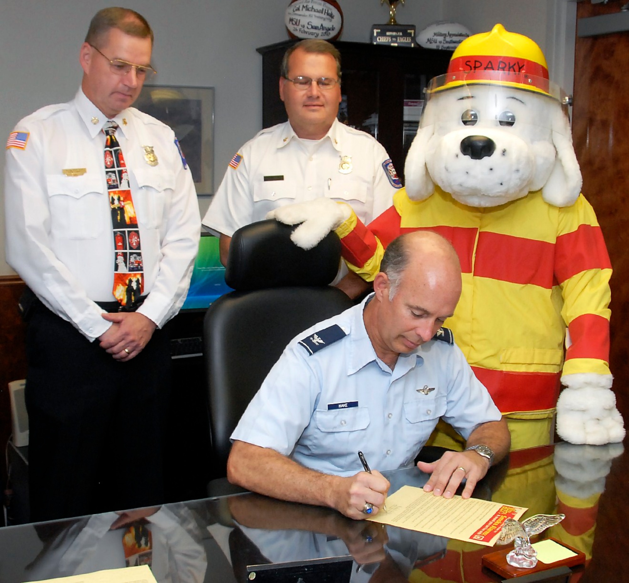 Col. Michael Hake, 82nd Training Wing vice commander, signs the Fire Prevention Week proclamation urging all Sheppard members to protect their homes and families with potentially life-saving messages.  Looking on are Sheppard Fire Department Fire Chief David Mounsey, Assistant Chief Rodney Ryalls and mascot Sparky.  Nearly 3,000 people die each year as a result of home fires and two-thirds of home fire deaths resulted from homes with no smoke alarms or non-working smoke alarms. The 2010 theme is Smoke Alarms:  A Sound You Can Live With! (U.S. Air Force photo/Mike Litteken)