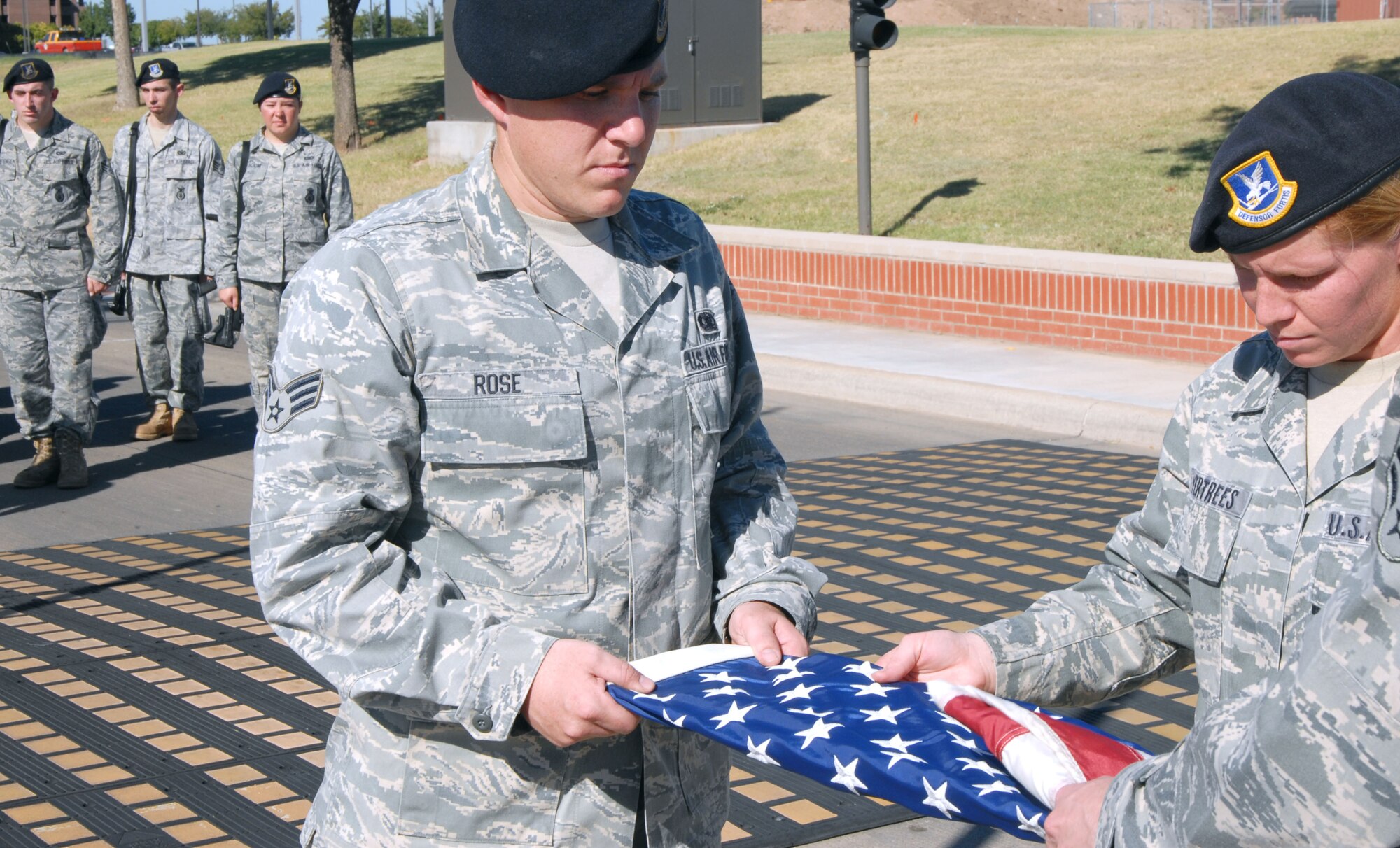 GOODFELLOW AIR FORCE BASE, Texas -- 17th Security Forces Squadron members, Senior Airman Mikael Rose and Staff Sgt. DeAndra Vertrees assist in folding a flag Sept 28, during a ceremony commemorating the 5th anniversary of Airman 1st Class Elizabeth N. Jacobson's death. Airman Jacobson was the first Security Forces member and the first Air Force female to be killed in action in Iraq. (U.S. Air Force photo/Airman 1st Class Jessica D. Keith)