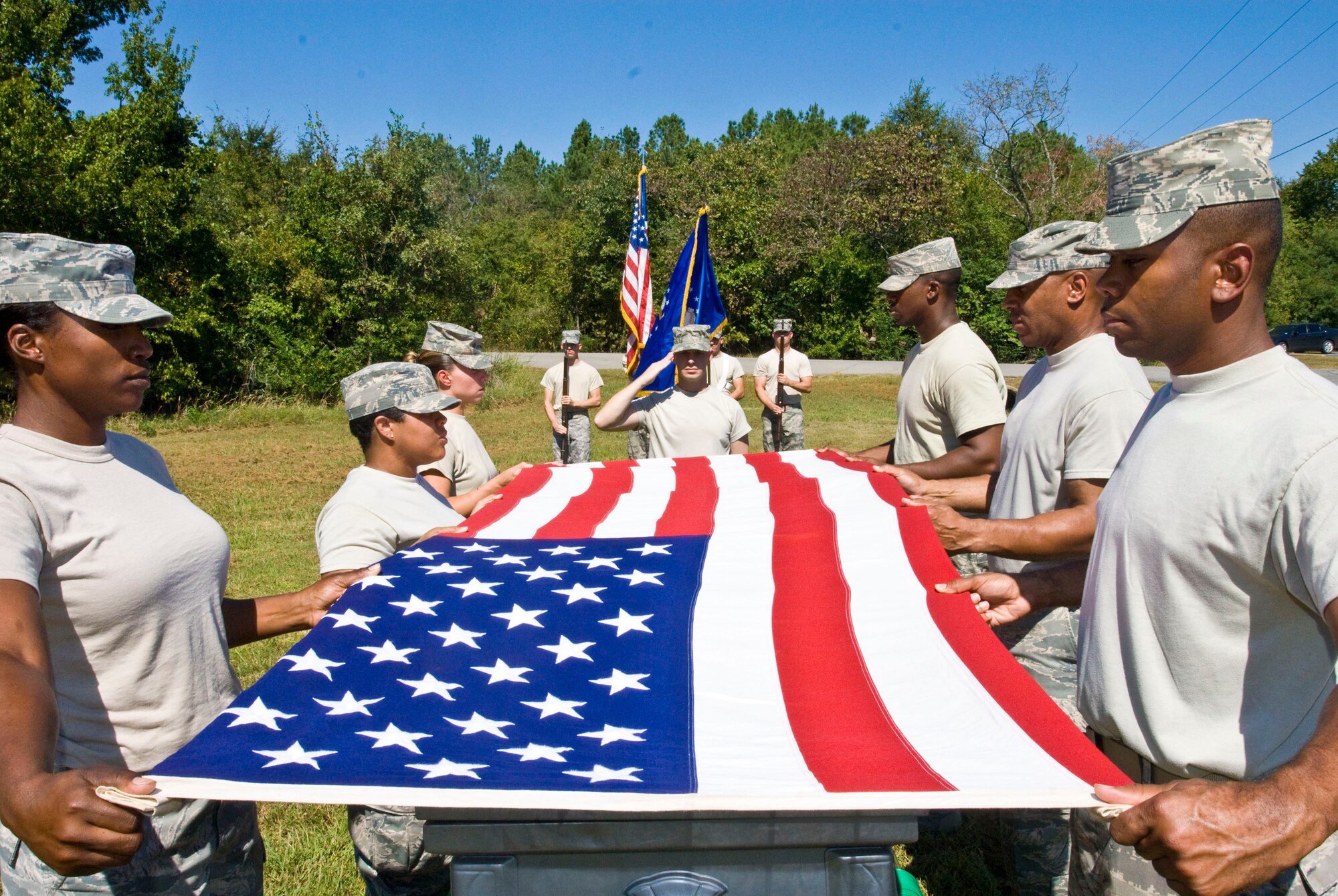 Base honor guard members position the American Flag for ceremonial folding during a pre-test evaluation here Sept. 28. Airmen serve as honor guard members for 90 days on duty, then serve another 90 days on-call for a total of 180 days. (U.S. Air Force photo by Staff Sgt. Nestor Cruz)