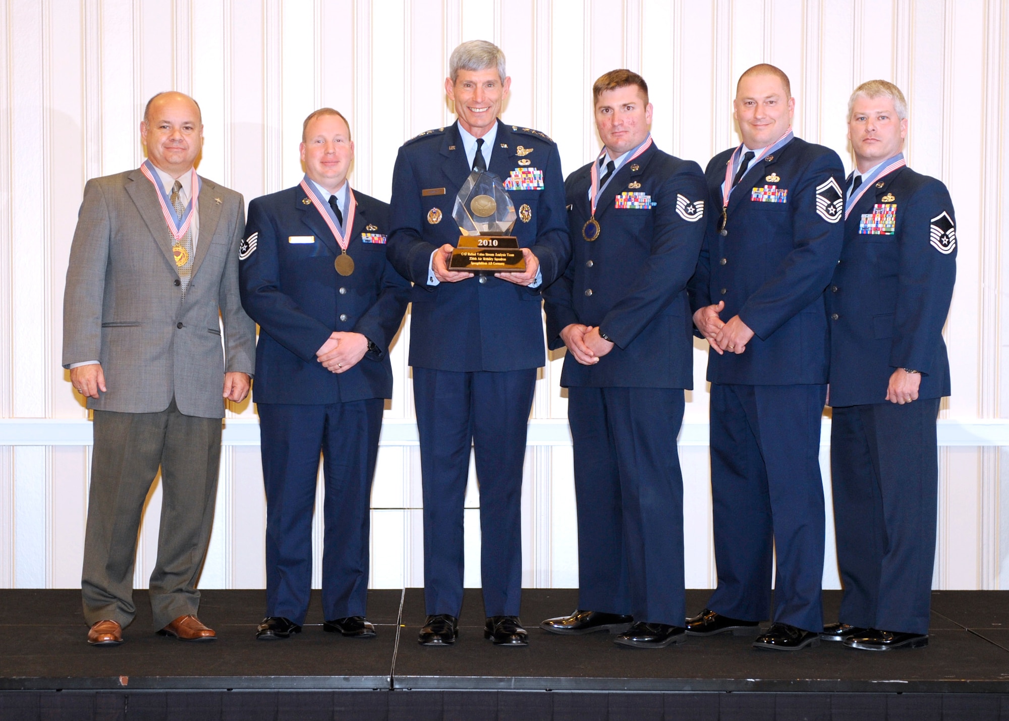WASHINGTON -- Gen. Norton Schwartz, Chief of Staff of the Air Force, center, presents the Chief of Staff Team Excellence Award to members of the 726th Air Mobility Squadron Sept. 14. Mr. Eric Nolf, Tech. Sgt. Jason Conner, Tech. Sgt. Joshua Mursu, Senior Master Sgt. Robert Johnson and Master Sgt. James Pierce represented the C-17 team who rewrote maintenance manuals saving roughly $8.4 million in excess refuel work throughout the Air Force. (Courtesy photo)
